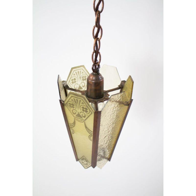 Hexagonal Lantern, Amber glass panels with antique coppered metal fixture. Glass panels alternate acid etched pattern and rippled glass

Material: Glass,Metal
Style: Art Deco,Traditional
Place of Origin: United States
Period Made: Early 20th