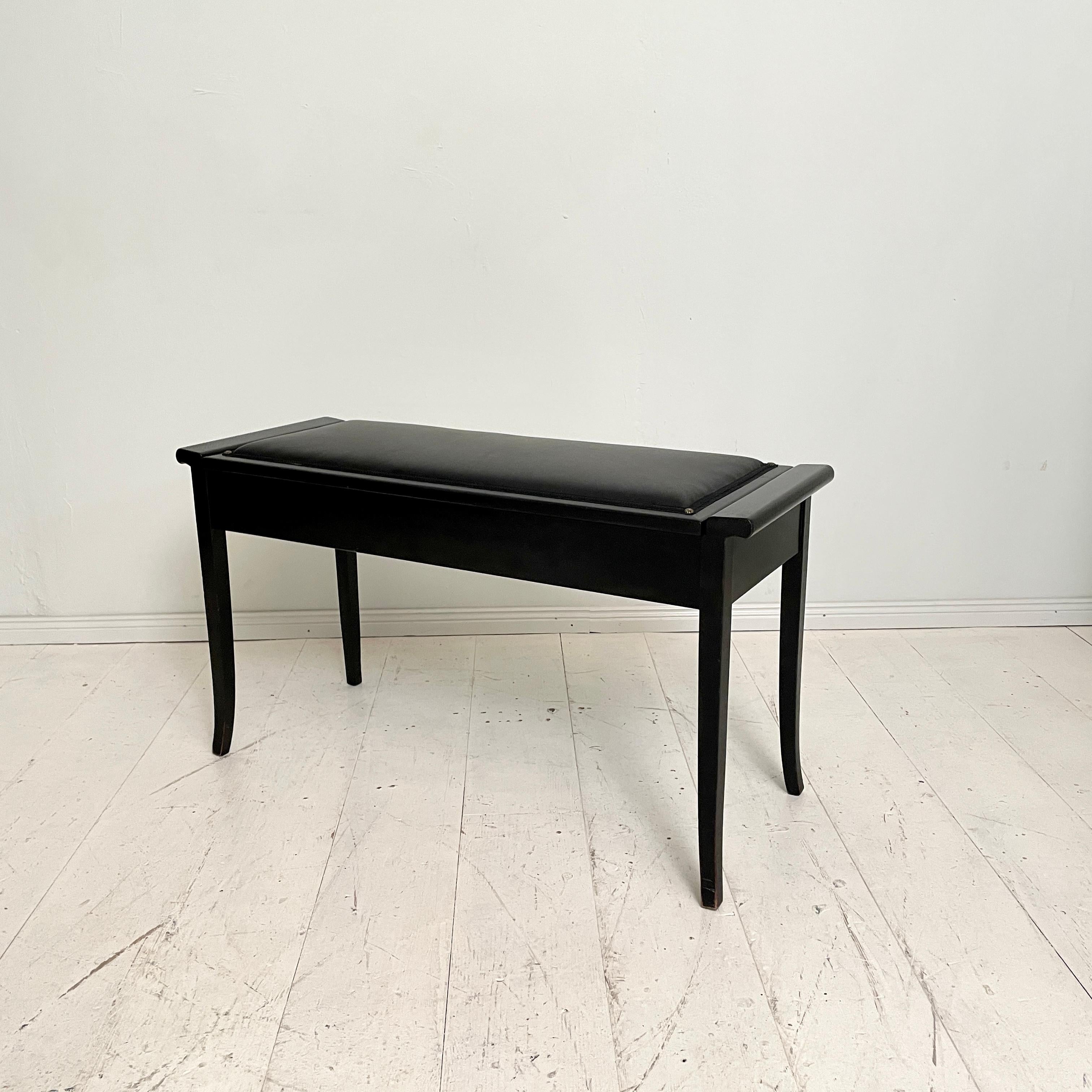 This beautiful Early 20th Century Art Deco Piano bench was made around 1925.
It is made out of Ebonized hardwood and the black leather seat was re-upholstered recently.
The seat of the bench can be opened and there is storage space for sheet