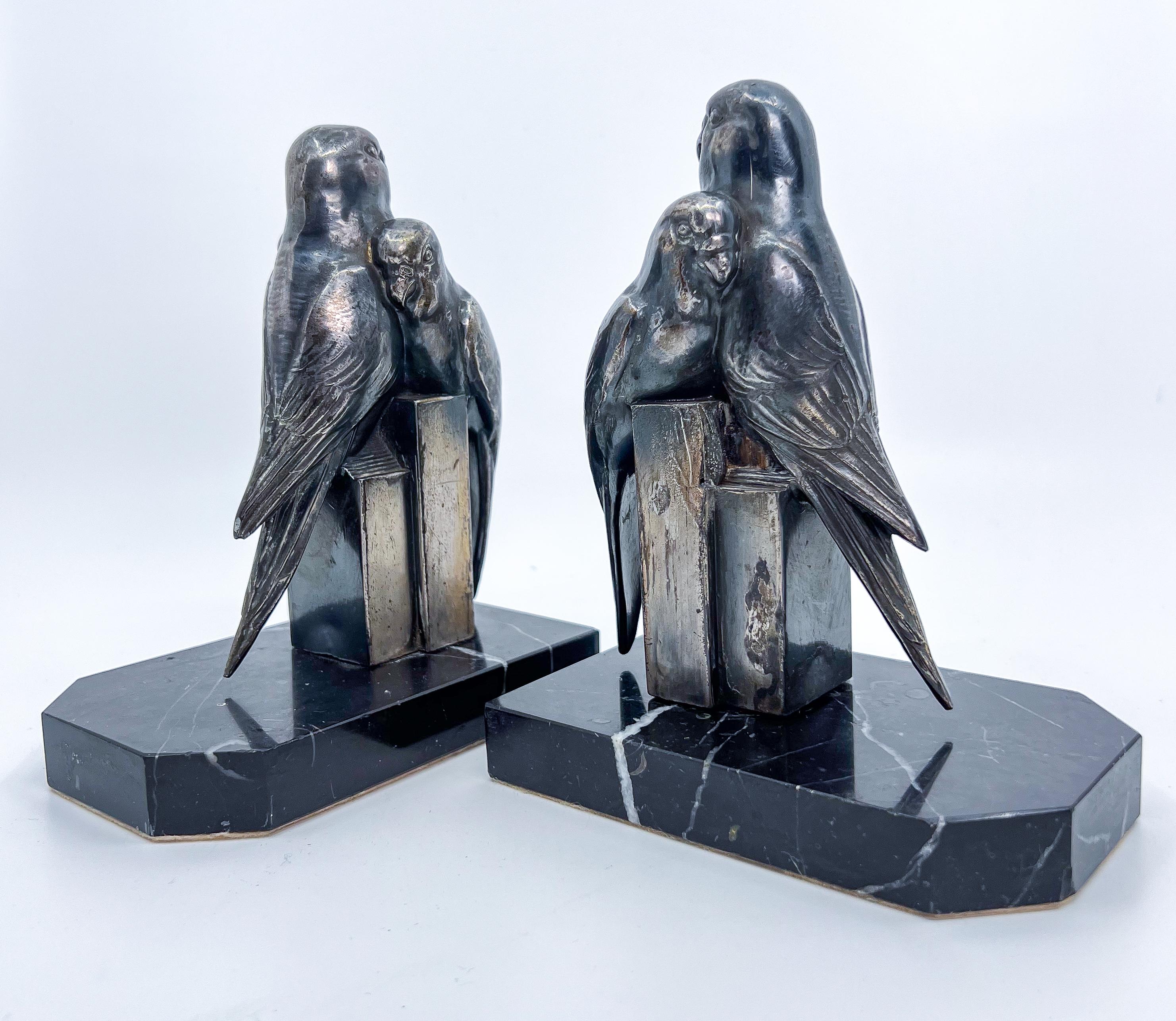 A pair of bookends from the French Art Deco period. Parrot or Paradise birds, made of casted spelter (zinc alloy) patinated in multiple colors. On onyx marble supports.