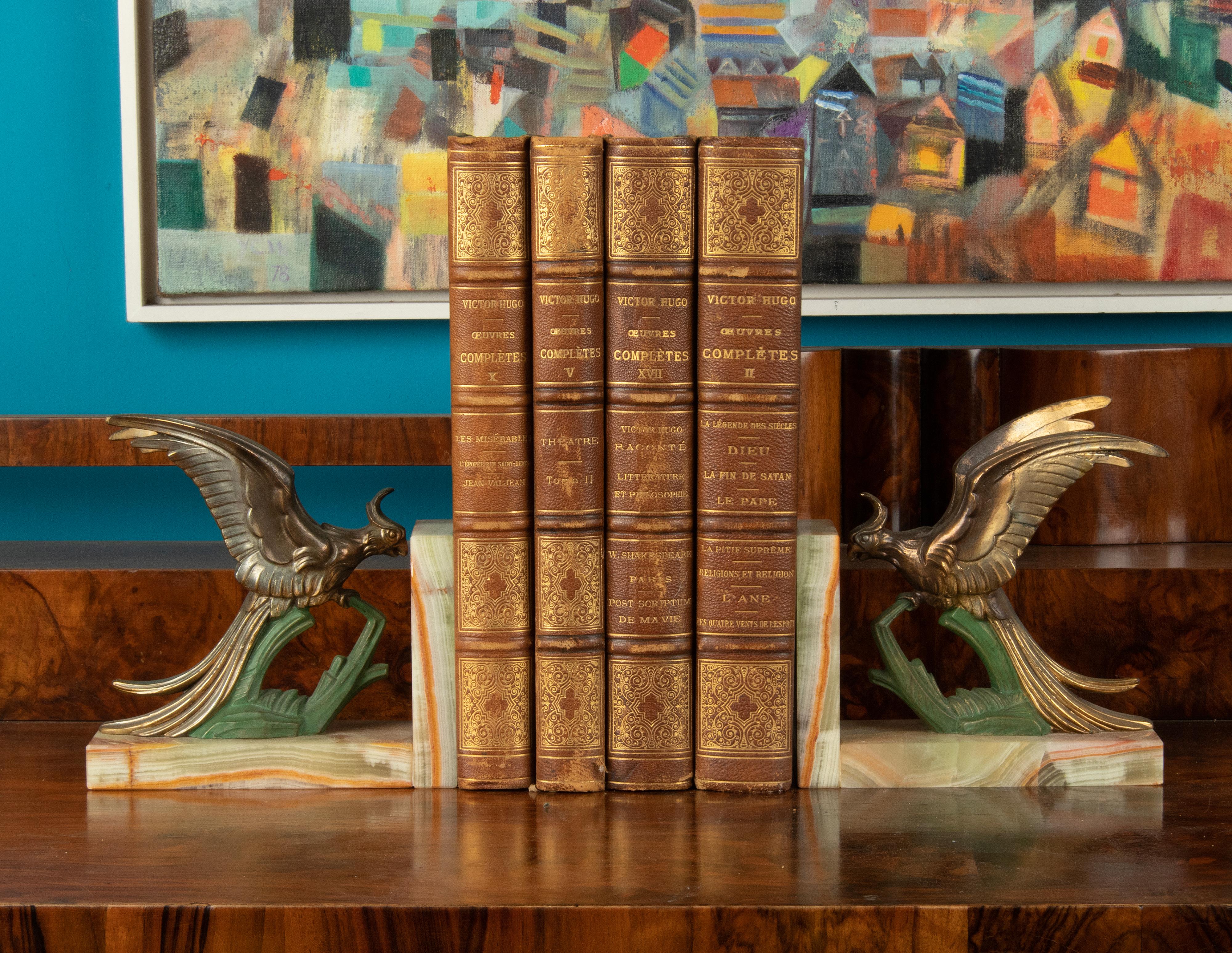 A pair of bookends from the French Art Deco period. Parrot or Paradise birds, made of casted spelter (zinc alloy) patinated in multiple colors. On onyx marble supports.