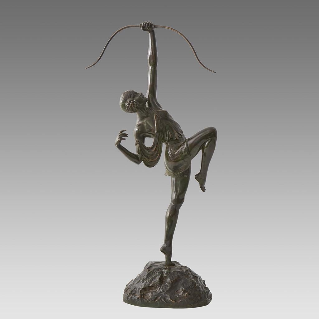Figure emblématique en bronze Art déco du début du XXe siècle représentant Diane chasseresse vêtue d'une tunique, la main levée au-dessus de la tête lâchant son arc. Excellente patine verte riche et très beaux détails finis à la main, signé Le