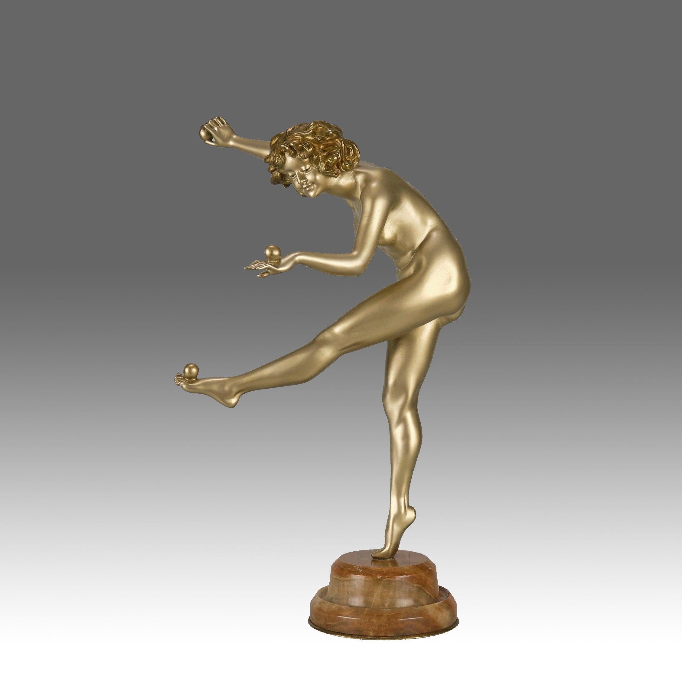 Affascinante figura in bronzo dorato e smaltato dell'inizio del XX secolo di una ballerina in posa equilibrata che tiene in mano delle palline da giocoliere, con colori dorati e smaltati molto fini e dettagli eccellenti, firmata Cl.J.R. Colinet e