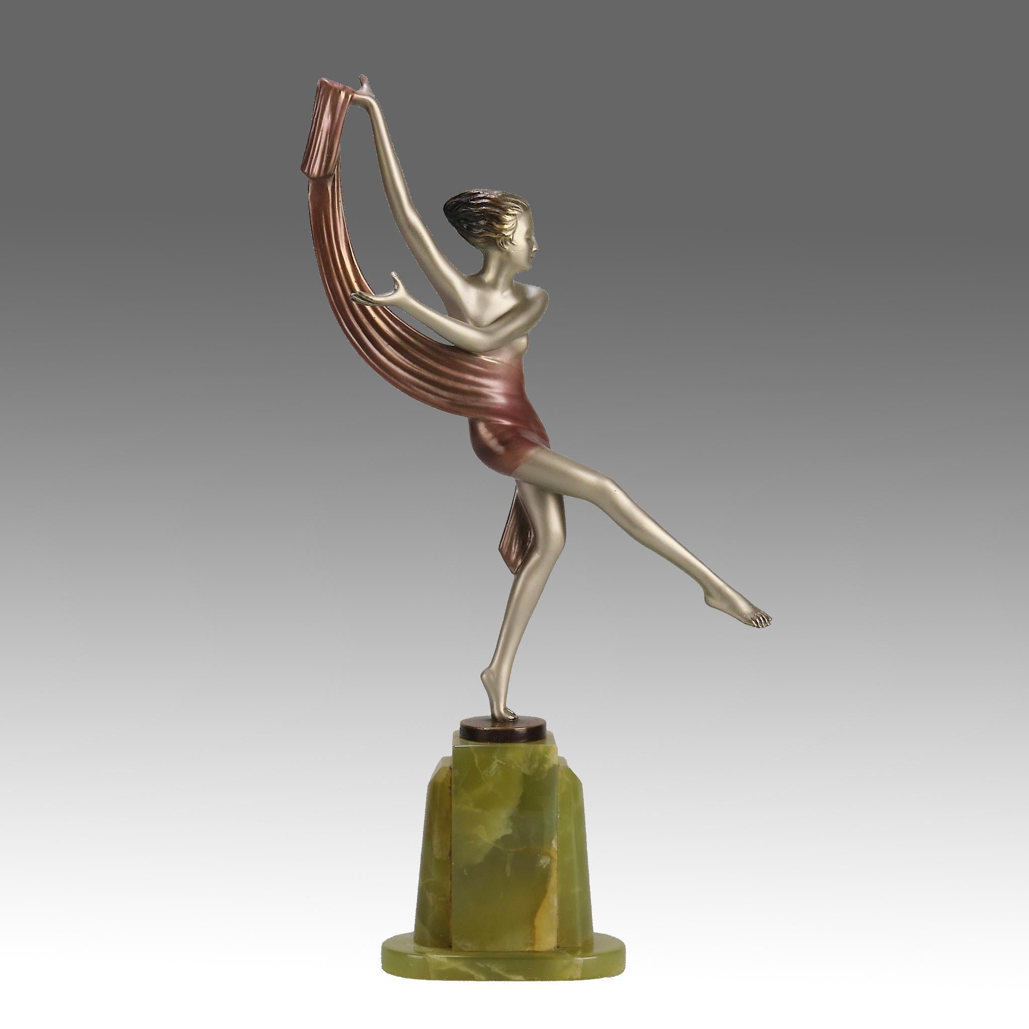 Un joli bronze Art déco du début du 20e siècle, peint à froid en argent et émail rouge, représentant une jeune beauté énergique en train de danser avec une écharpe drapée autour de son ventre. Le bronze présente d'excellentes couleurs et de très