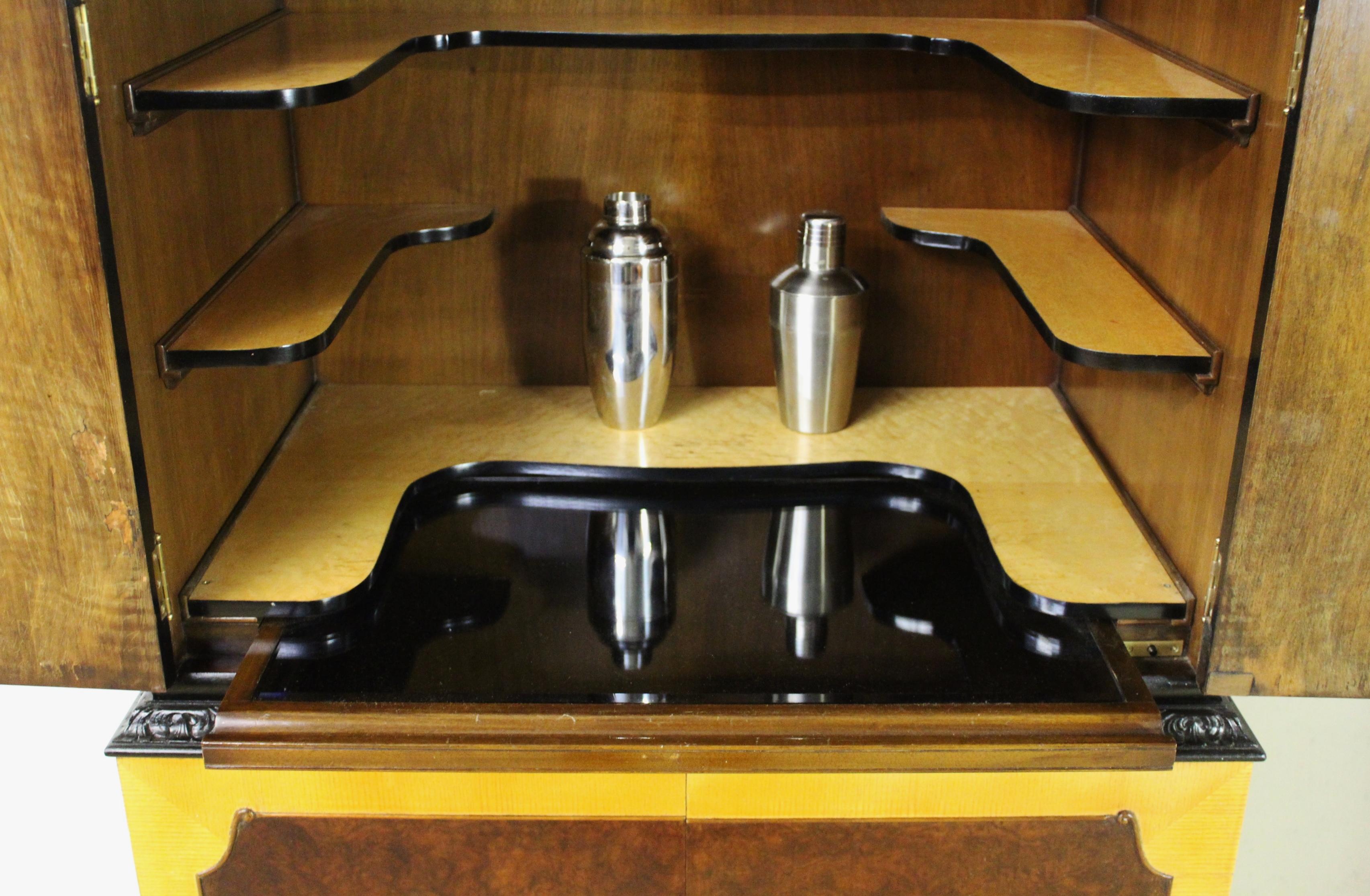 A striking domed top walnut cocktail cabinet from the Art Deco period. Well made in walnut, with burr walnut, burr maple and maple wood veneers. The door fronts are fitted with attractive burr walnut veneers , surrounded with maple wood veneer