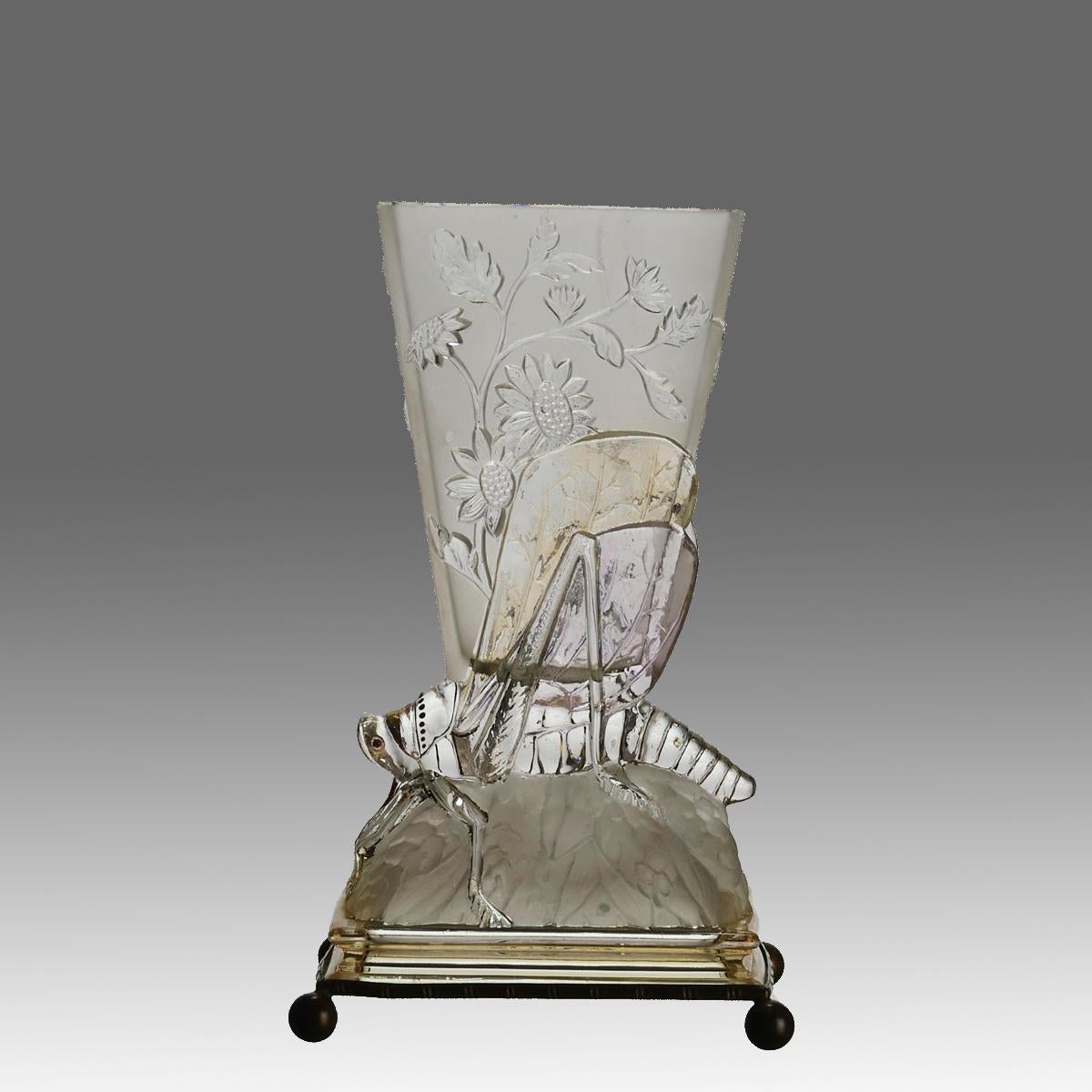 An eyecatching early 20th Century glass vase. decorated with raised floral design above the figure of a grasshopper on a rock with excellent hand finished detail and mounted on a silvered stepped base with four circular bun feet, signed

ADDITIONAL