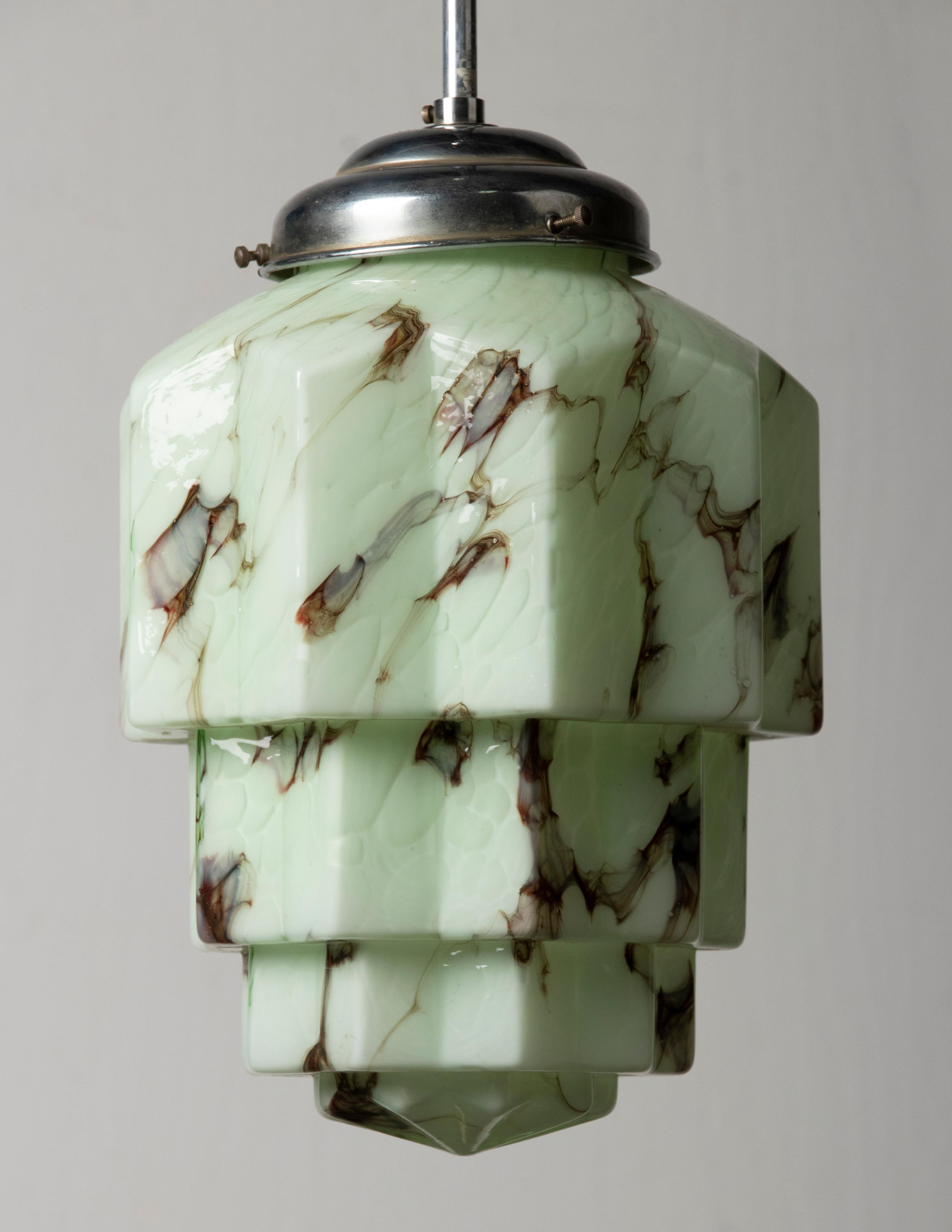 An Art Deco period Skyscraper Lantern/Hallway lamp. The molded green art glass shades is also called Skyscraper model. When the light is switched on, ti givers a warm and atmospheric light. 
The design is inspired by the Art Deco architecture, like