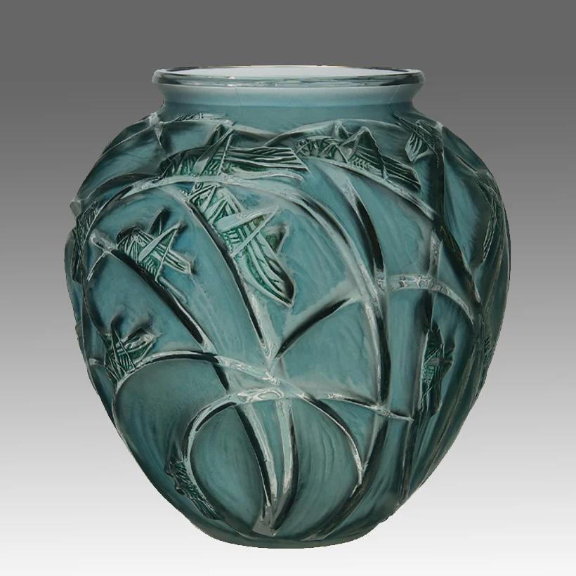 Impressionnant vase en verre clair et dépoli Art déco français du début du XXe siècle, avec un paysage de branches teintées en bleu et des figures en relief de sauterelles teintées en vert. Le vase, signé R Lalique, est orné de fins détails finis à