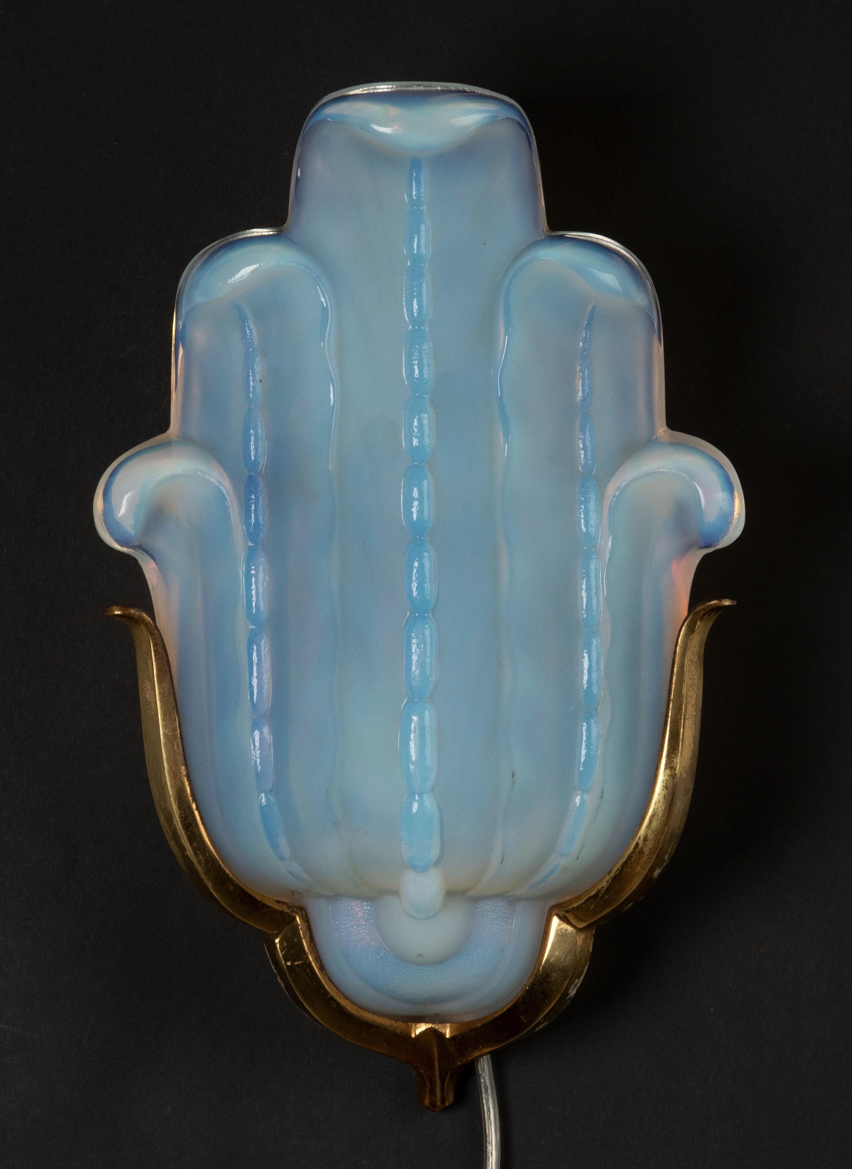 A single Art Deco wall light with an acanthus leaves shaped opalescent glass, signed Ezan, France. The opaline has a beautiful deep blue mother-of-pearl color. On a metal mount with copper color finish. On both sides the copper finish have some