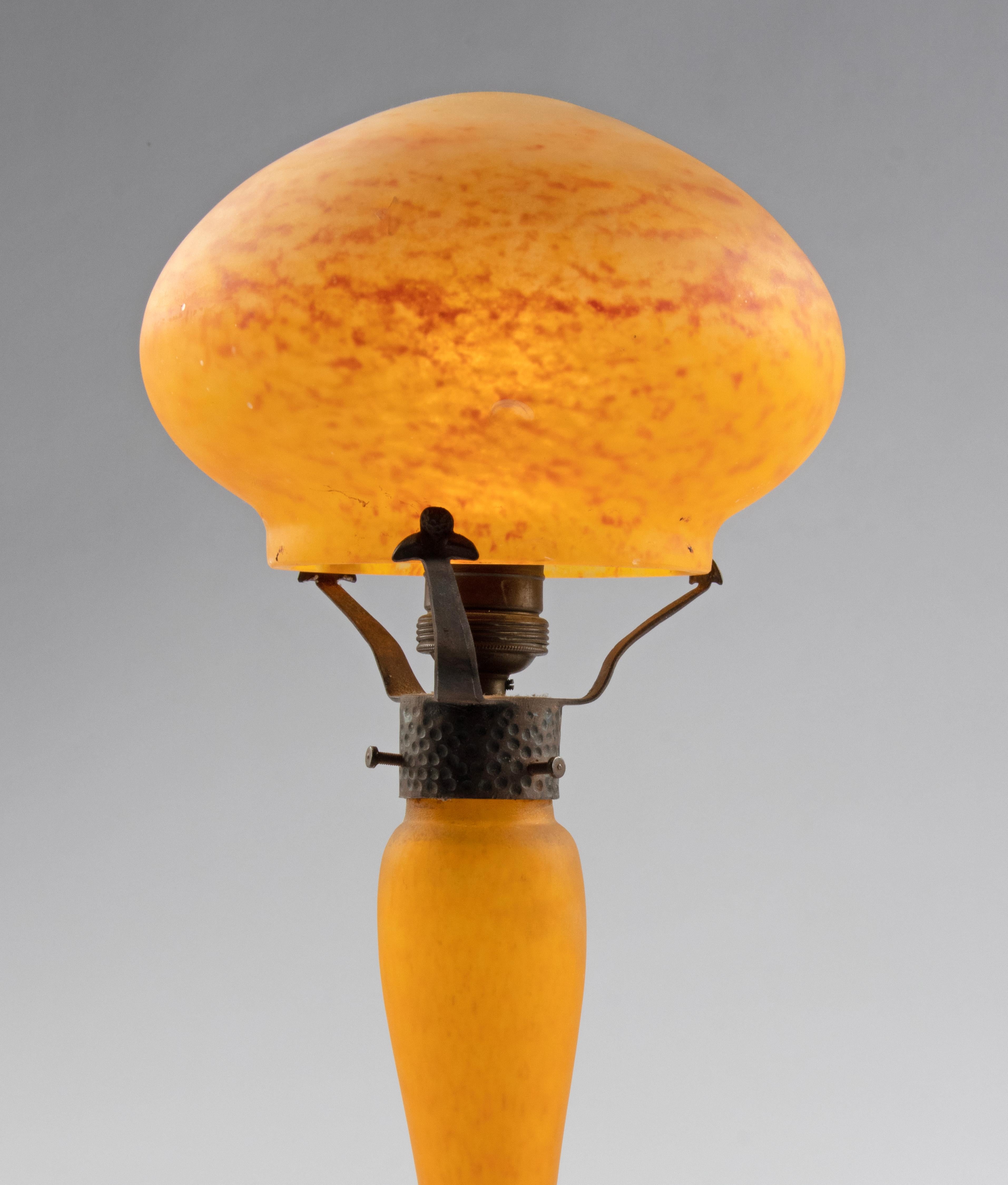 A large Art Deco period mushroom shaped table lamp made of Yellow and Orange paste glass (Pate de Verre). The mushroom lamp diffuses a warm and felted light. A timeless and fashionable lamp. The lamp shade is resting on three forged iron brackets.