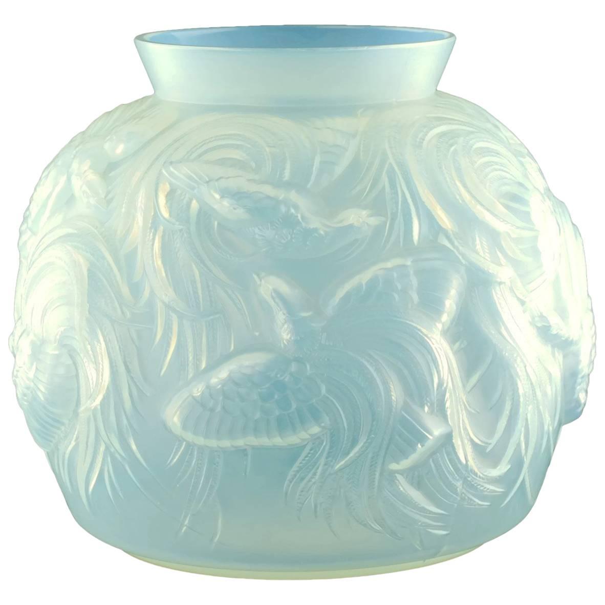 This large Art Deco opalescent art glass bowl was made by well regarded French glass manufacturer, Sabino. The piece has a globular form with a simple flared rim and features all-over molded decoration in the form of Birds of Paradise. Particular