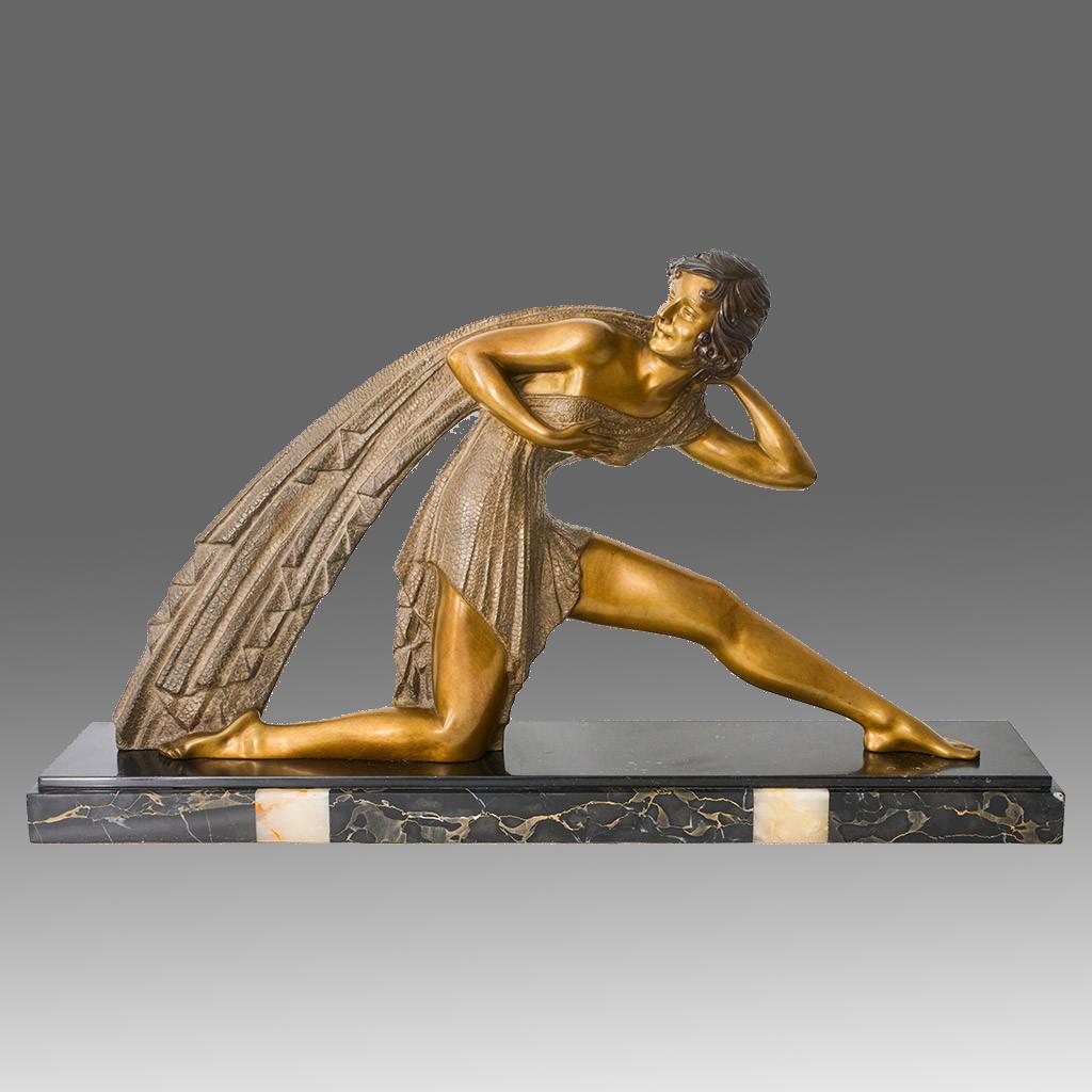 A large and impressive early 20th Century silvered and gilt bronze figure of an Art Deco beauty on one knee knelt down as her other leg is extended. The lady dressed in a flowing dress with a long shawl over her shoulder. The bronze with very fine