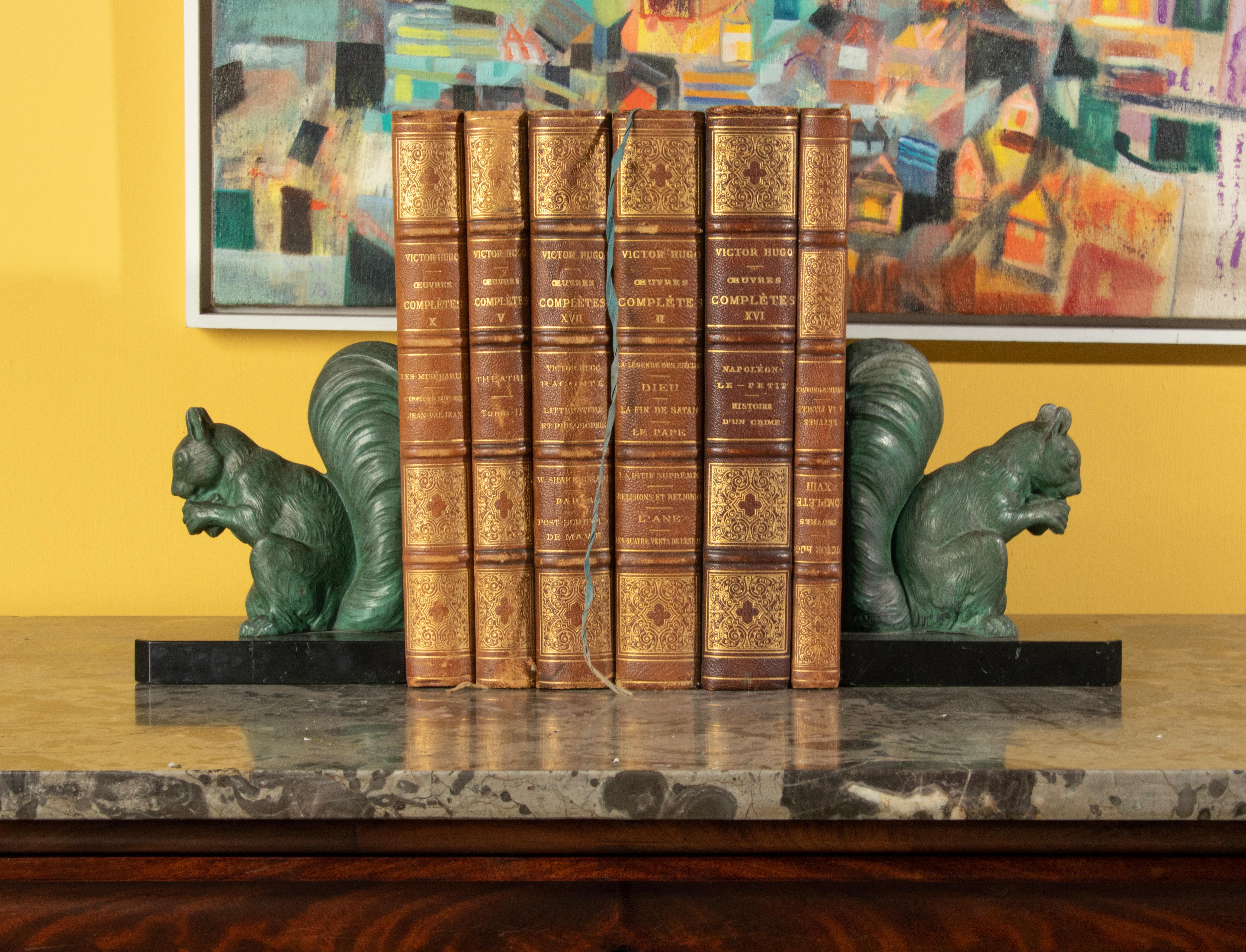A pair of Art Deco period bookends with squirrels. Made of casted spelter, with a green bronze-like color patina. On a black Belgian marble plinth. They have no signature. The spelther and marble arre in good condition. On one of the marble a small