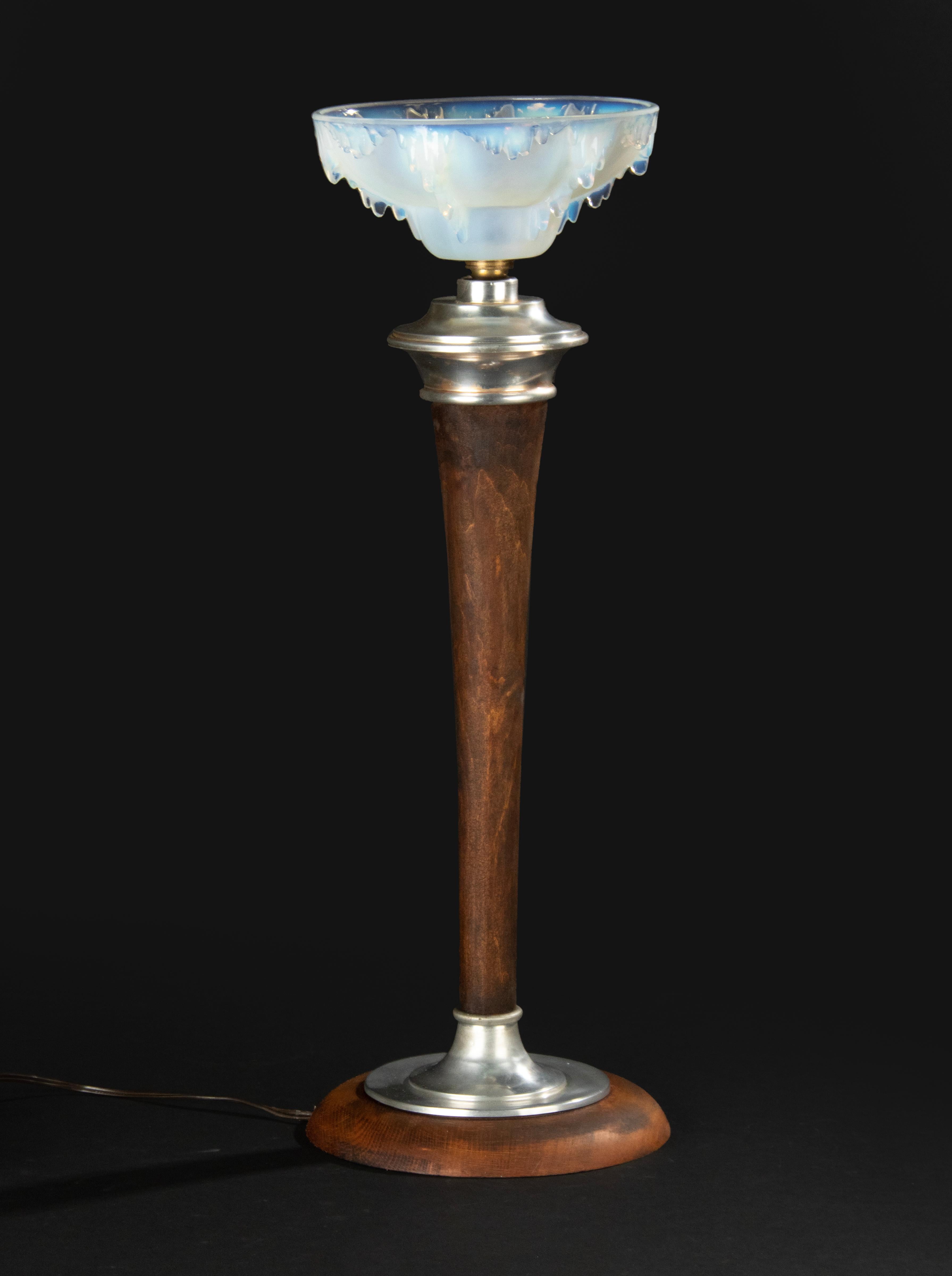 A large Art Deco table lamp made of beechwood and nickel plated metal. On top a blue opalescent glass molded glass lampshade in the style of Ezan. It has no signature. Bayonet lamp socket. The lamp is in working order. Glasswork is in good