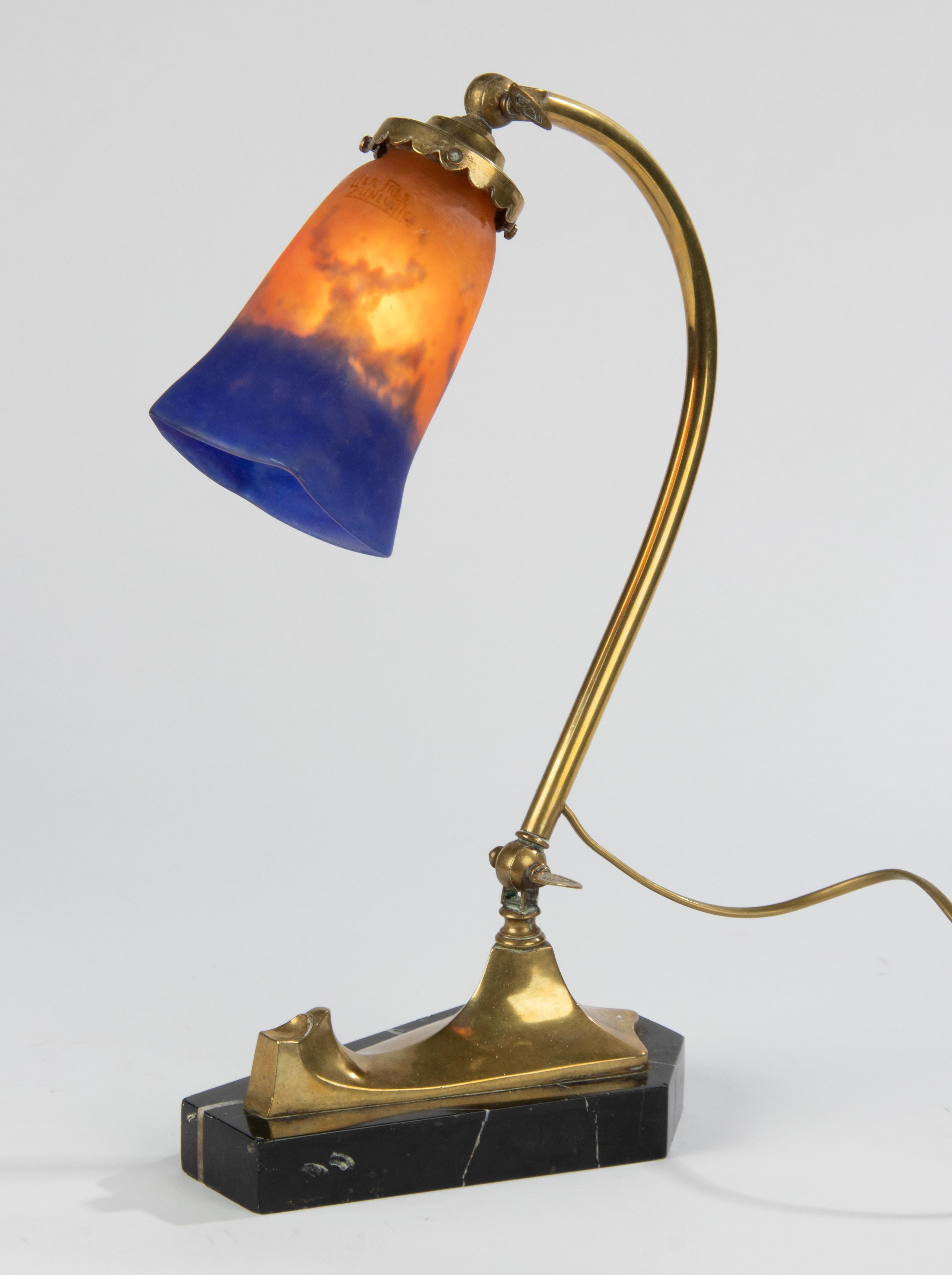An elegant table lamp or desk lamp, made of brass on a marble plinth. The lampshade is made of pasta glass, also called 