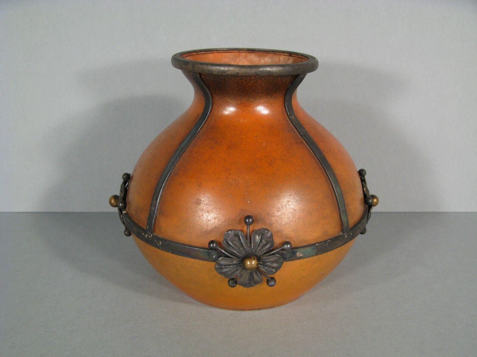 This exquisite Art Nouveau vase is crafted from colored glass and features a wrought iron mount adorned with four stylized flowers. The mount is signed 