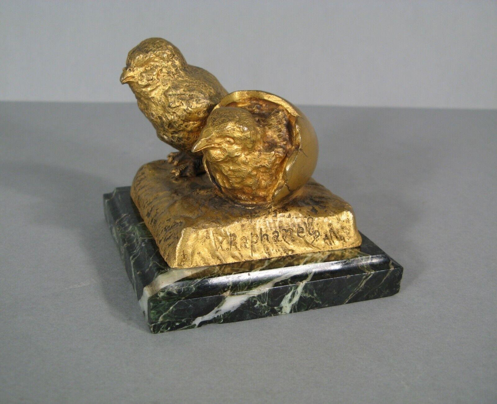 This charming and rare bronze sculpture depicts two chicks, one of which is emerging from an egg. The piece is signed on the right side of the base by Xavier Raphanel, a French sculptor (1876-1957). The sculpture features a golden patina and is