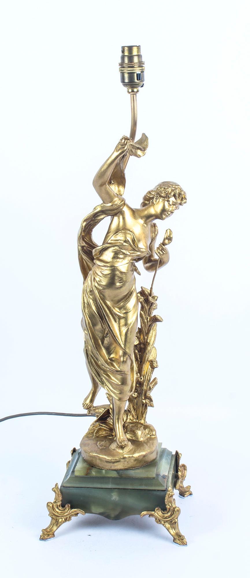 This is a beautiful antique Art Nouveau gilt metal and onyx table lamp of a beautiful lady, circa 1910 in date.

The lamp features a standing lady dressed in classical attire and holding a flower in one hand, she is raised on a green onyx base