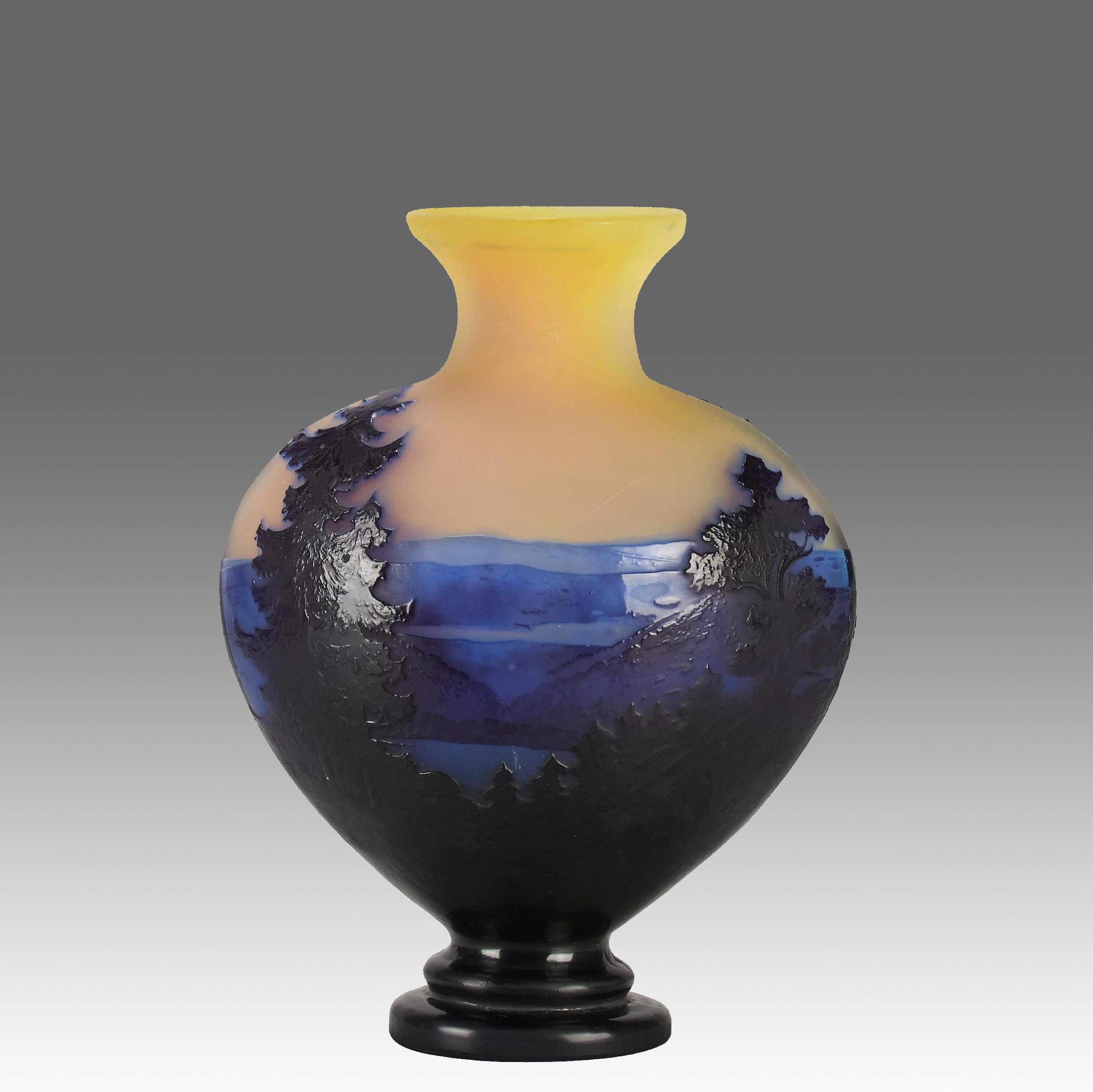 Vase en verre camée français de la fin du XIXe siècle, décoré d'arbres en relief de couleur bordeaux foncé, d'un paysage montagneux bleu et d'un champ jaune panaché. Les détails et les couleurs sont excellents. L'œuvre est signée Galle en