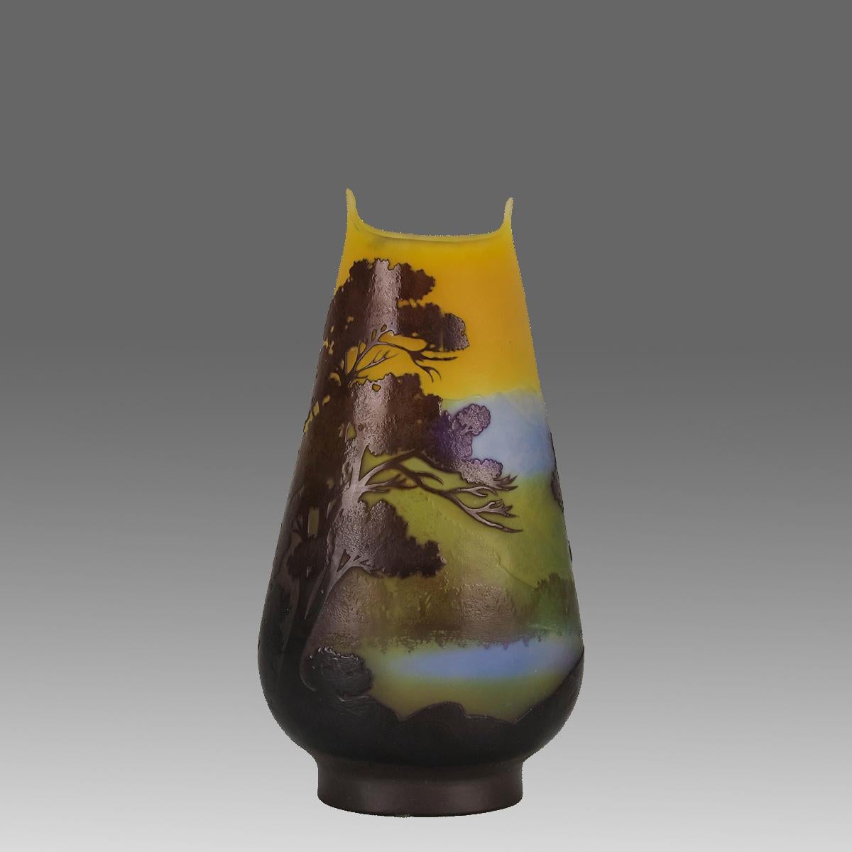 A spectacular late 19th Century French cameo glass vase of Art Nouveau form with layered colours of deep purple, blue, green and yellow depicting a lake amidst a tree lined landscape, signed Gallé.

ADDITIONAL INFORMATION
Height:                    