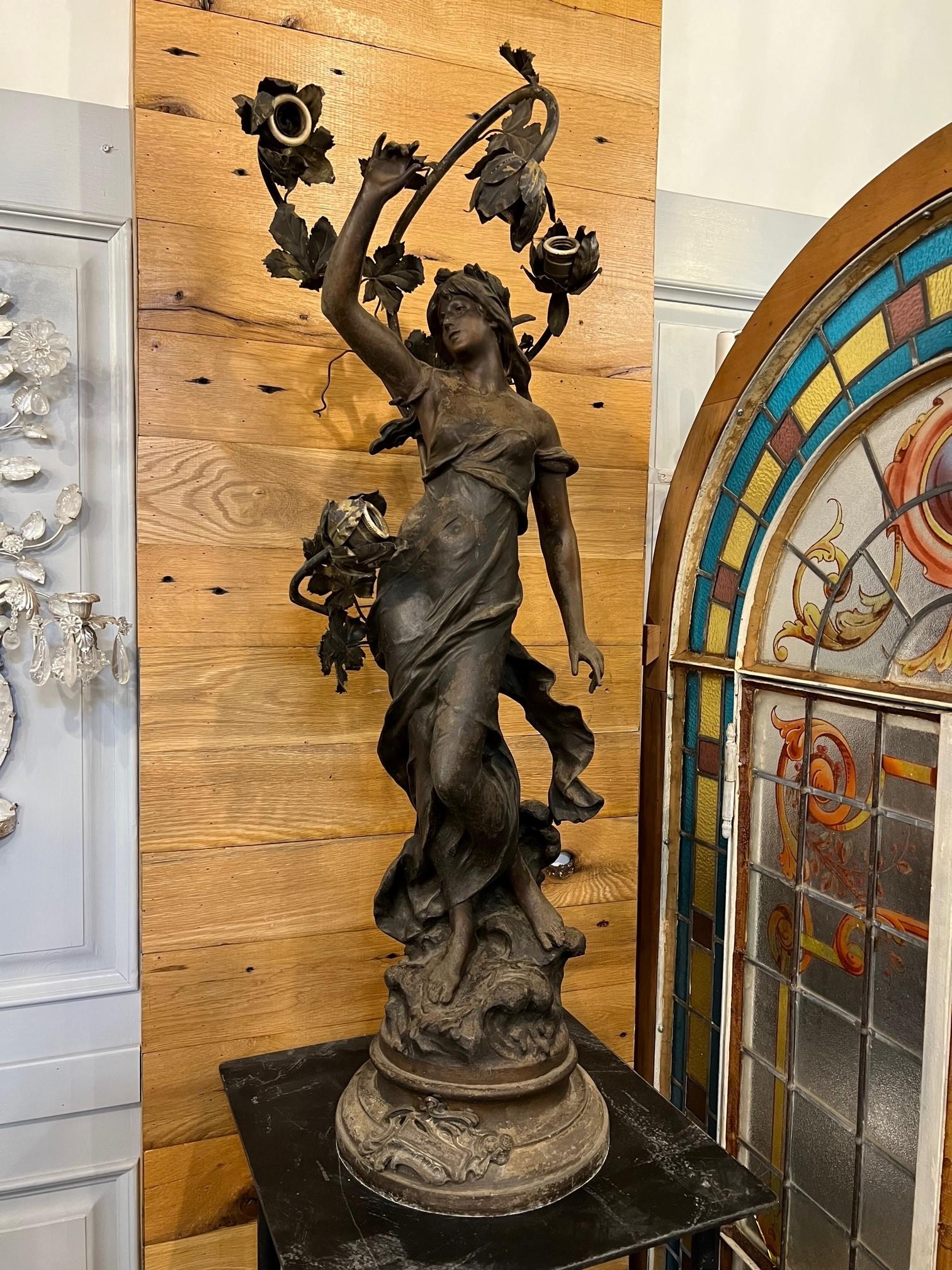 Lampe de poteau Newel Art Nouveau du début du 20e siècle, également connue sous le nom de lampe de pilier. Ce luminaire représente une belle femme au bras levé et quatre lumières. Les lampes à poteau Newel étaient utilisées pour éclairer les maisons
