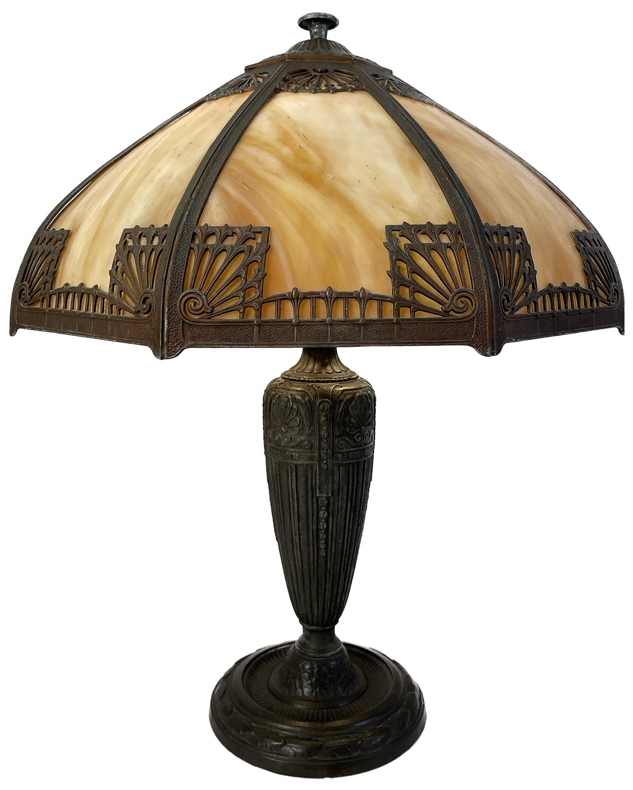 An early 20th century Art Nouveau style lamp with slag glass and bronze detail.

Dimensions: 23.5