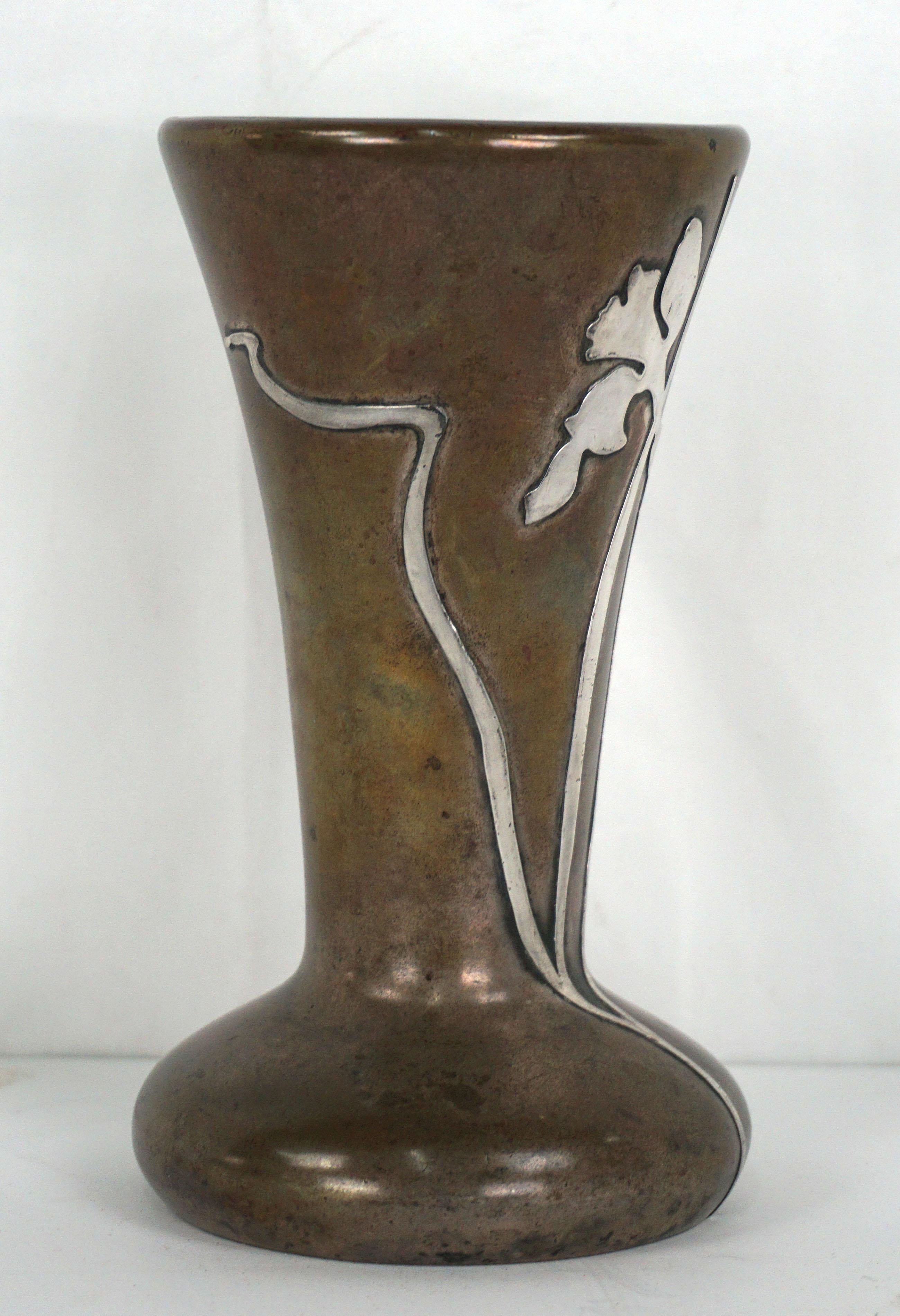 Early 20th Century Art Nouveau Sterling Overlay on Bronze Daffodil Vase

This beautiful vase was designed and handcrafted by the artisans at Heintz Art Metal Shop circa 1915. Hand forged in bronze, the vase has a bulbous foot with graceful flared