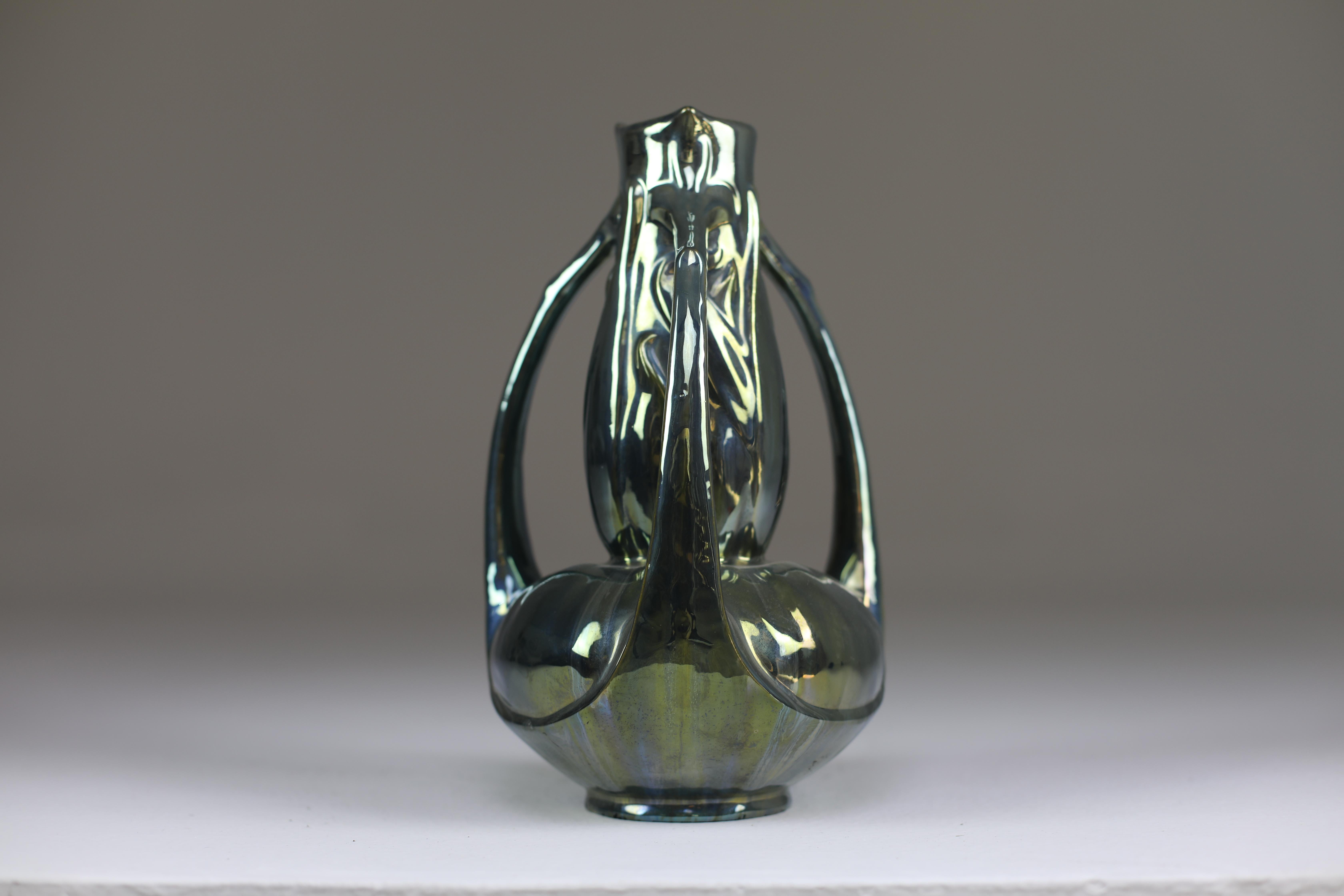Un magnifique vase ancien en céramique fabriqué à la main par Alphonse Cytère, connu pour avoir développé cette finition métallique. 
Style Art nouveau typique. 
Ce modèle à trois poignées est rare. Signé à la base.
1890-1910. 

------

Nous sommes
