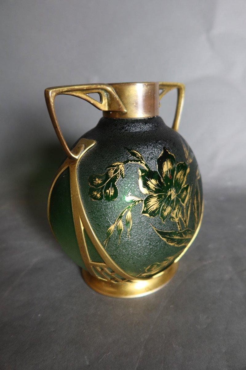Vase im Stil von Daum in Balusterform aus grünem Granitglas, säuregeätztes Dekor mit Blumen- und Blättermotiv, veredelt mit Vergoldung. Diese Vase hat einen für den Jugendstil sehr charakteristischen Messingrahmen. Zeitraum 1900. Auf der Unterseite