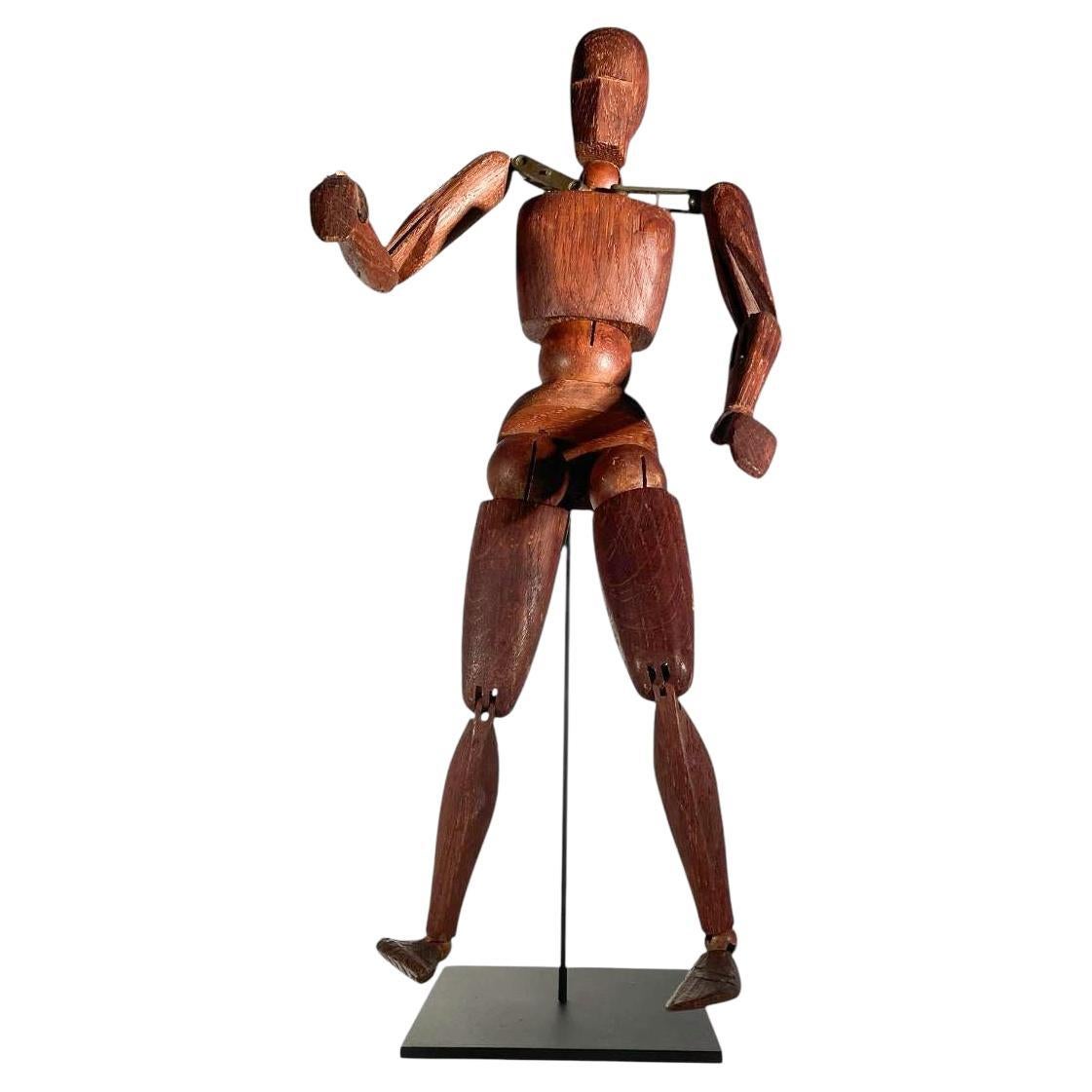 Personnage articulé en bois sculpté de style Art déco. Connues sous le nom de mannequins d'artistes ou de figurines laïques, ces figurines posables étaient utilisées dans les cours d'art comme modèles pour dessiner des formes humaines. Maintenant