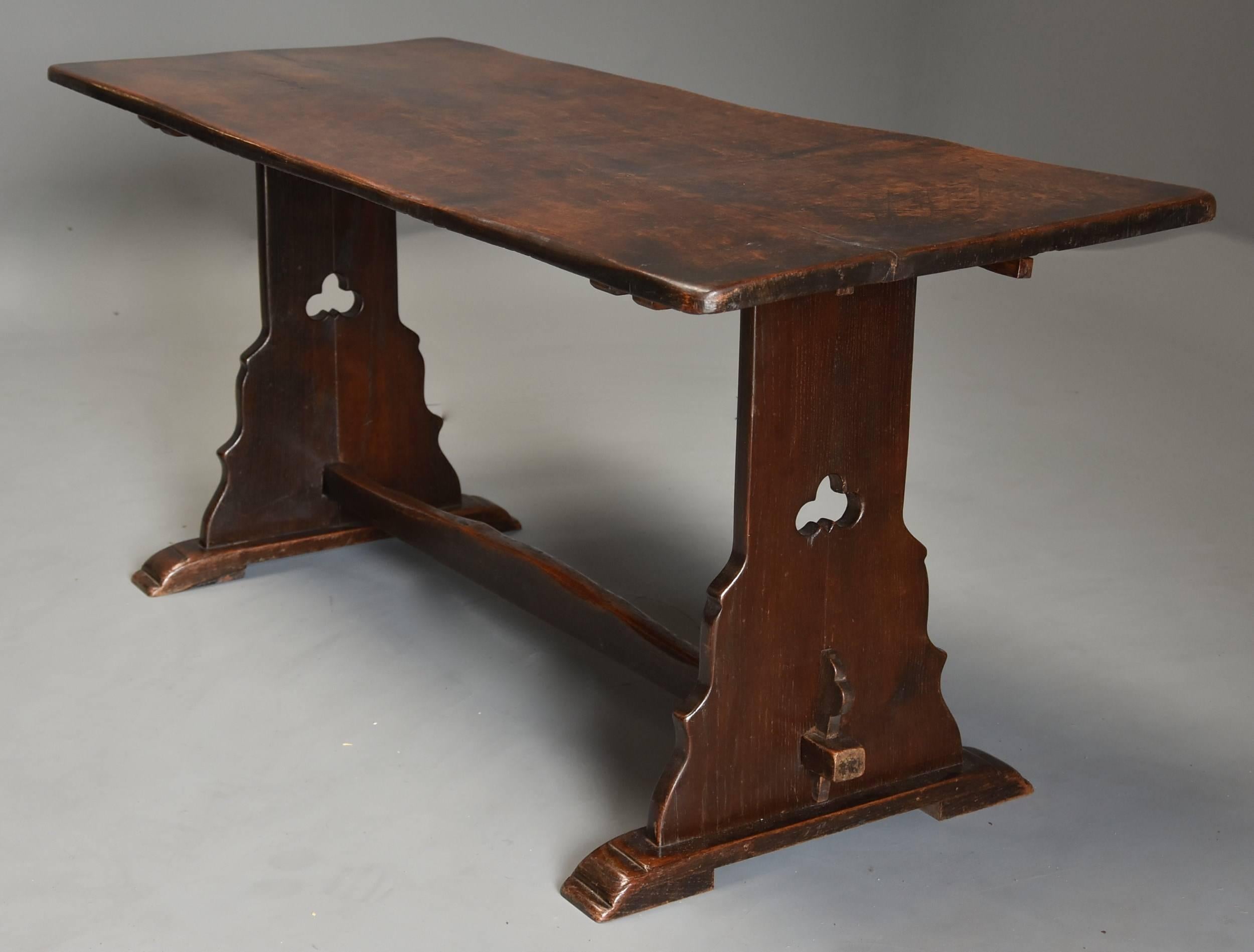 An early 20th century Arts & Crafts oak pegged trestle table with superb patina (color).

This table consists of a single plank top with a superb aged appearance and wonderful patina leading down to two shaped trestle supports with pierced trefoil