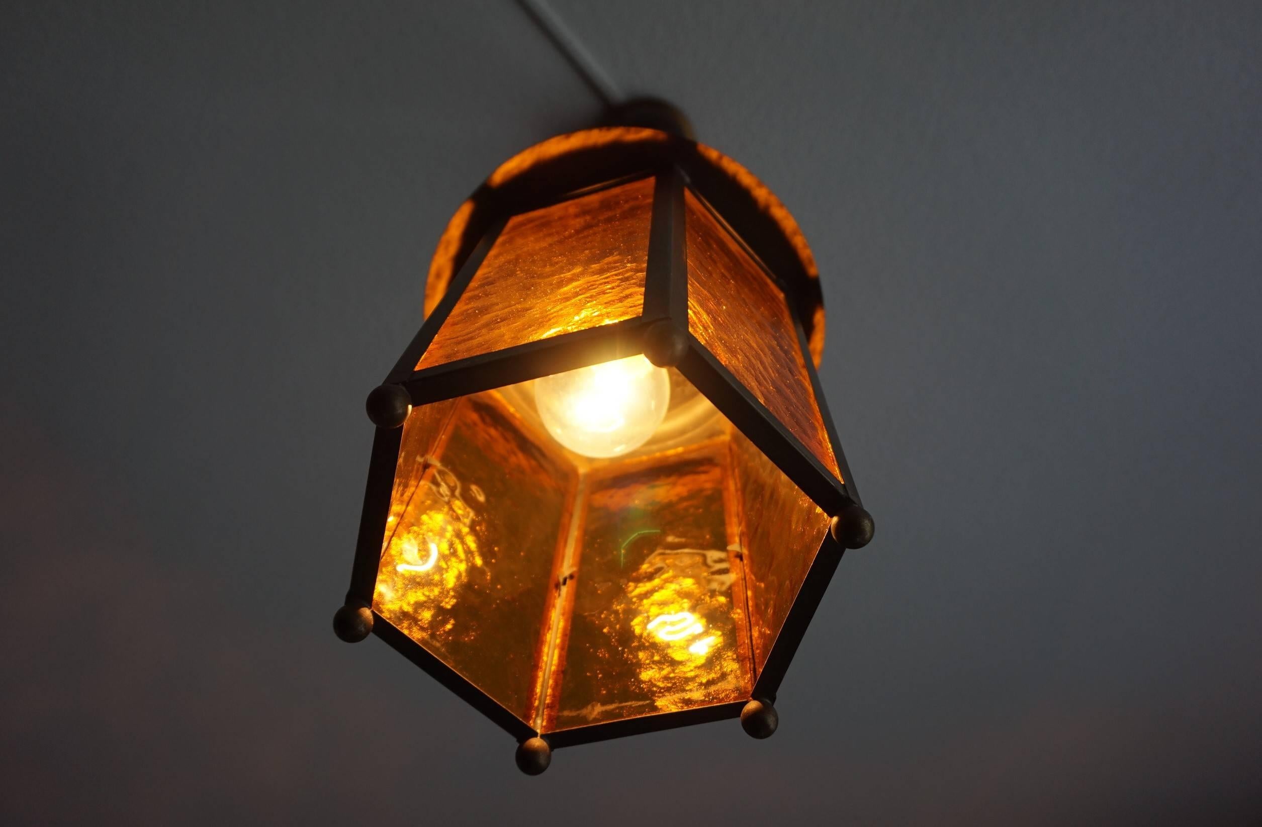 Embossed Early 20th Century Arts & Crafts Brass and Amber Glass Lantern Like Pendant For Sale