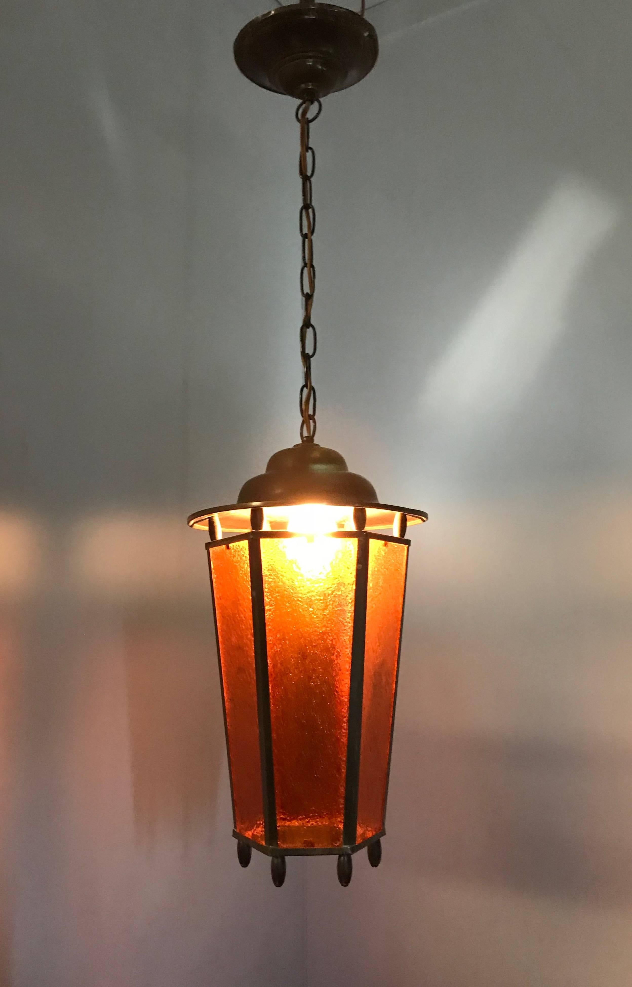 Beautiful design and color pendant.

This handcrafted light fixture from the early 1900s could be the light that brings just the right atmosphere to your entrance, landing or perhaps your bedroom. This no-nonsense, brass frame pendant has the most