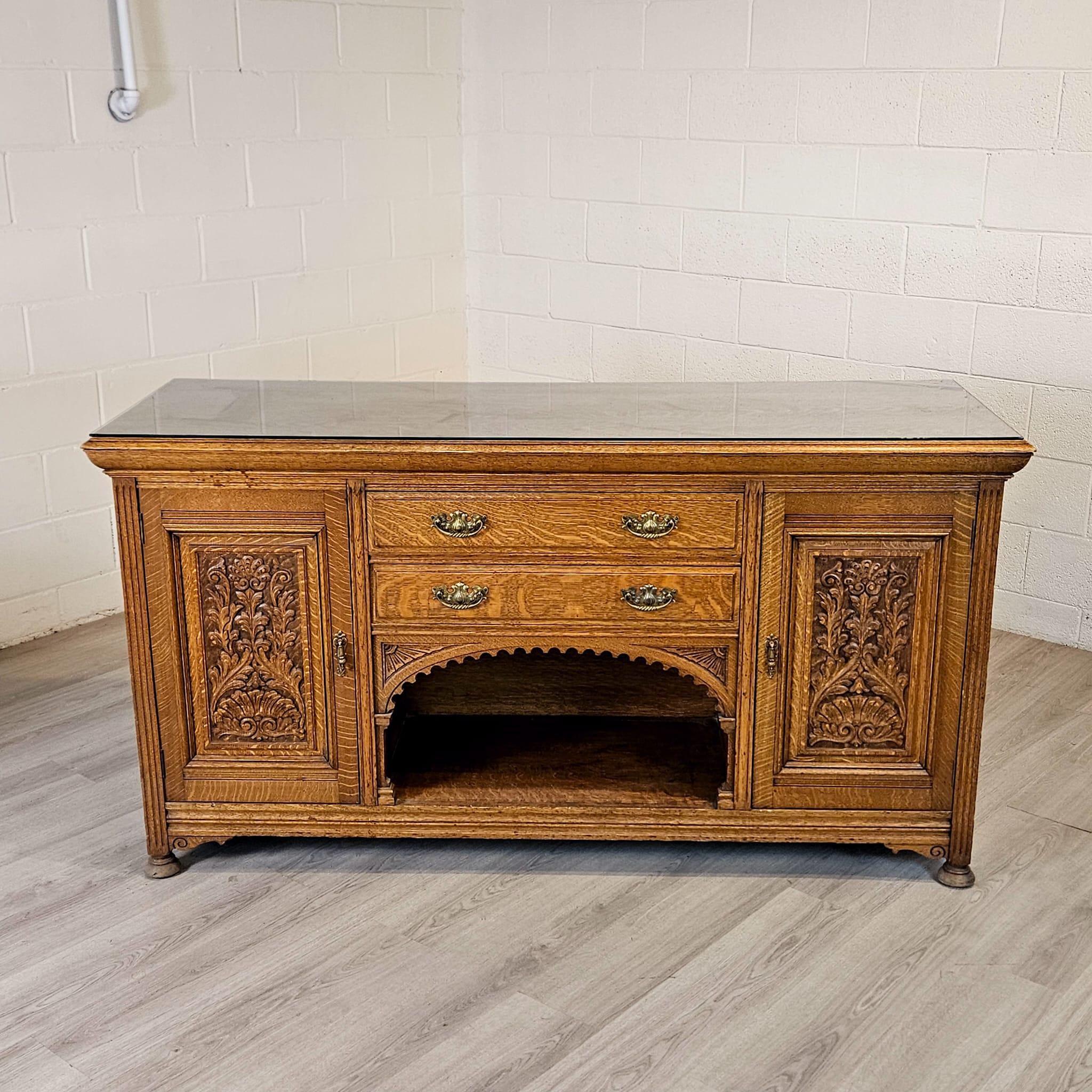 Early 20th Century Arts and Crafts Solid Oak Sideboard 

Add a touch of classic elegance to your space with this beautiful solid oak sideboard from the early 20th century. Featuring delicate carved details, quarter cut oak, and a wonderful colour,