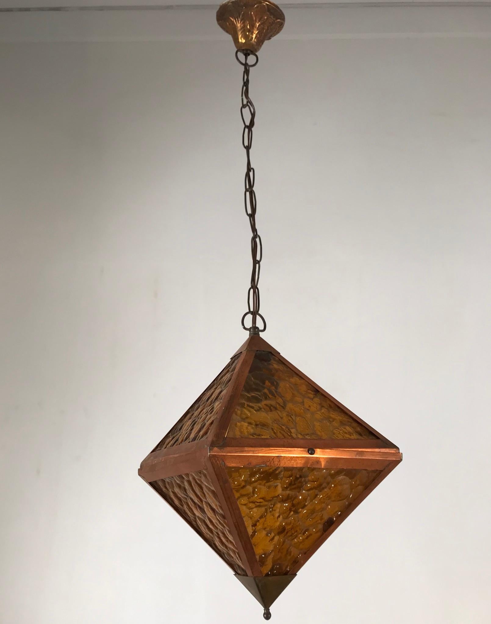 Rare shape, copper frame pendant with orange colored glass.

If you are looking for a unique Arts & Crafts pendant to grace your hallway, bedroom or perhaps a landing then this all handcrafted specimen could be perfect for you. The handmade, cubical