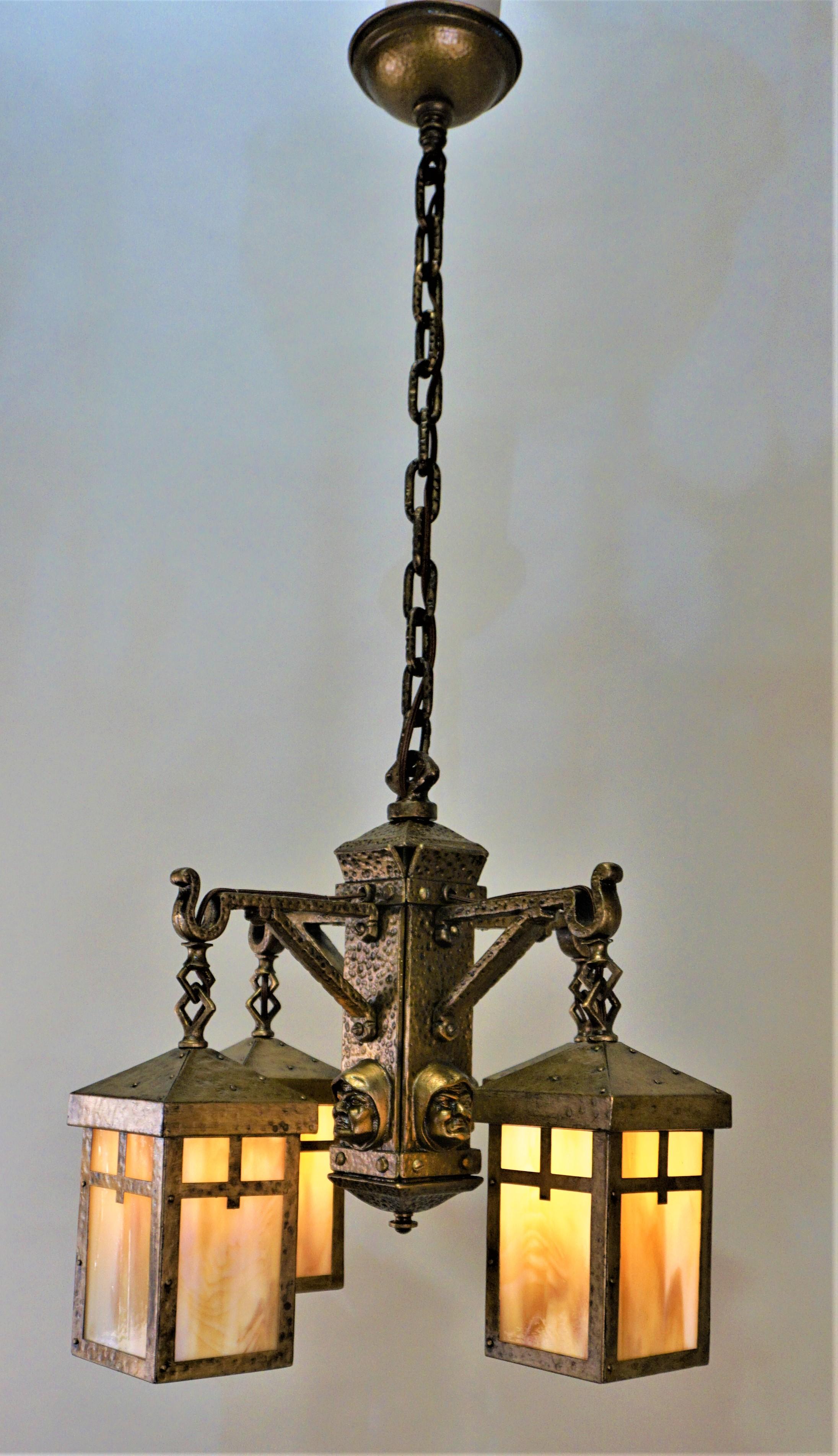 A great American Arts & Crafts chandelier from early 20th century four light slag glass shades hammered design frame with the monks head on each side a truly work of art.
Measurement 19.5