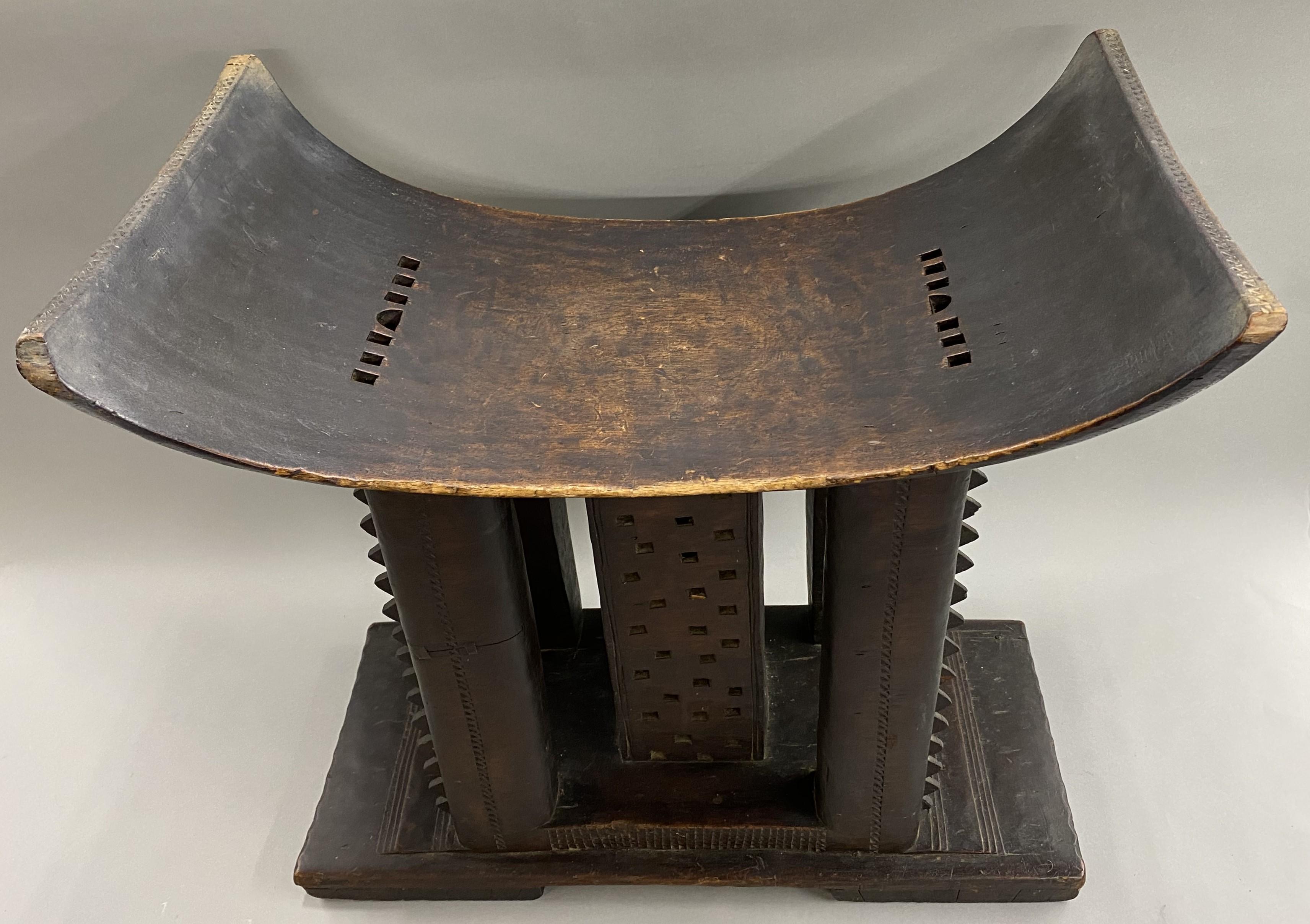 A fine example of a hand carved wooden stool from the Ashanti Tribe in Ghana, Africa, dating to the early 20th century in very good overall condition, with great patina, minor edge losses, and wear commensurate with age and use. Dimensions: 22 in H