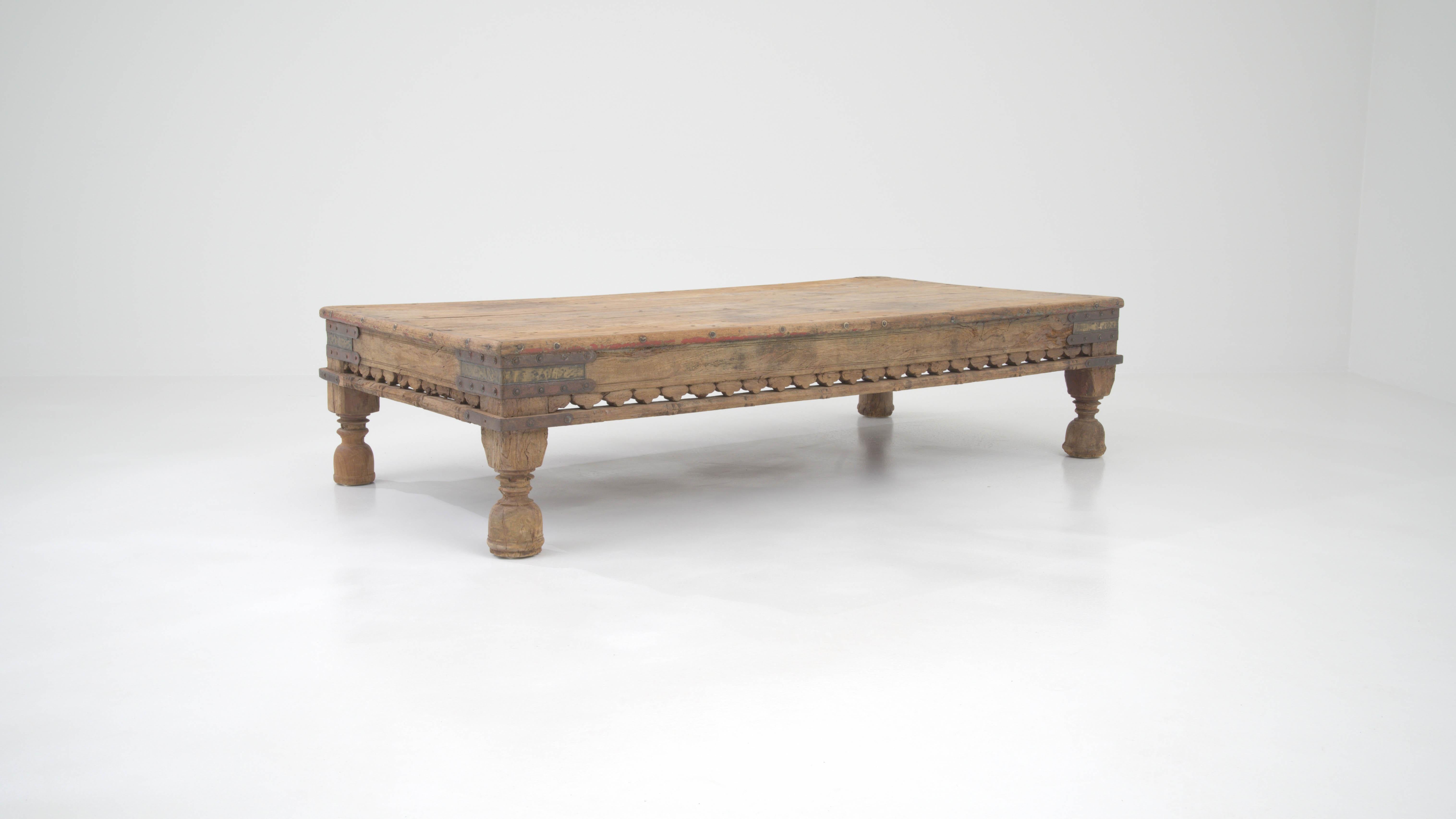 Introducing a piece of history into your living space with this early 20th-century Asian wooden coffee table. Crafted with a touch of antiquity, this sturdy, low-profile table is a testament to timeless artisanship. The robust legs, exquisitely