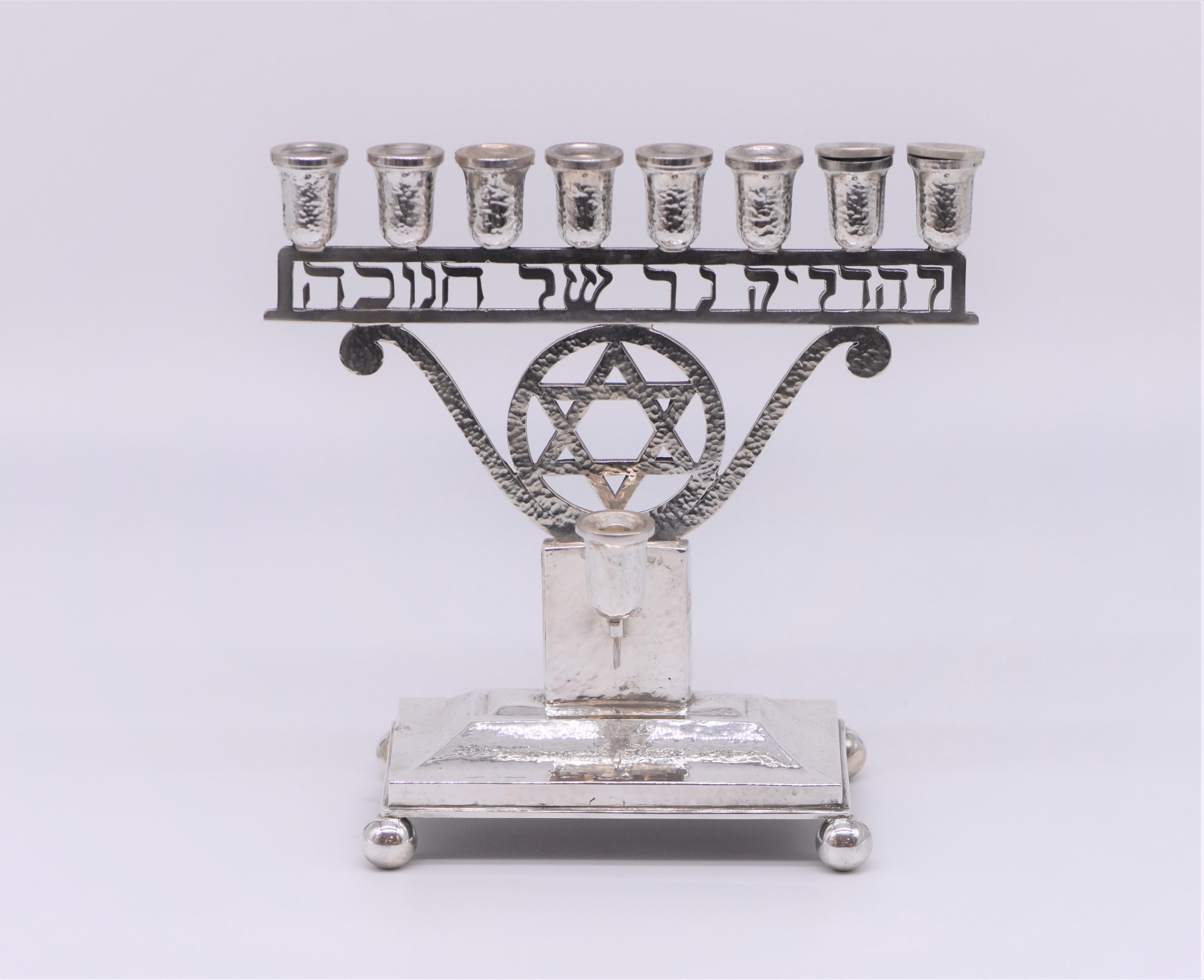 Handmade Austrian silver Jugendstil Hanukkah lamp Menorah, Vienna, circa 1920.
Of hammered design with raised rectangular base on four ball feet, the eight-light and detachable auxiliary light supported on a narrow openwork rectangular panel with