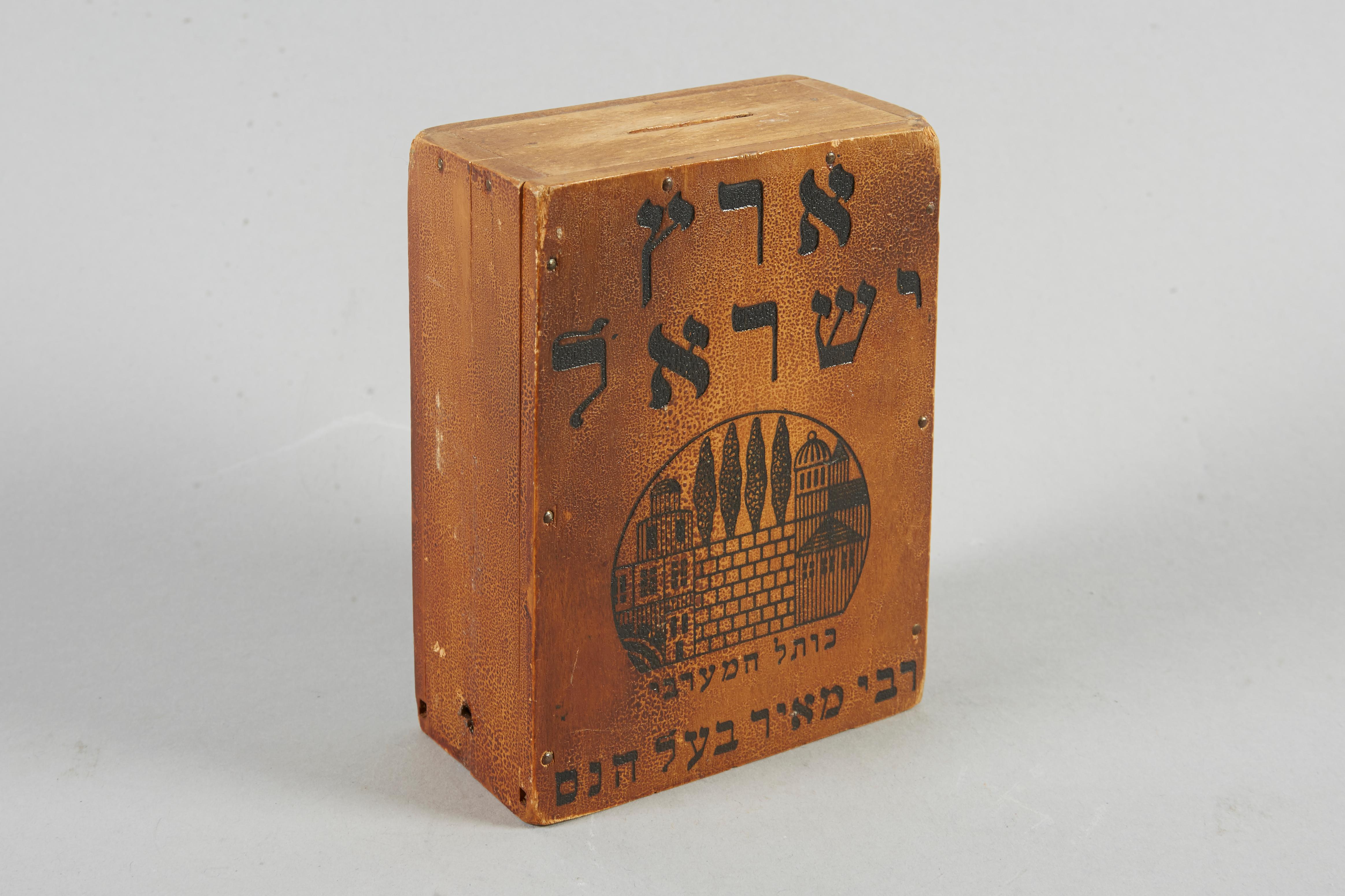 Judaica Charity box, made in Austria, circa 1920.
Printed with a scene of the Western Wall, inscribed in Hebrew “Land of Israel / Western Wall / Rabbi Meir Ba’al Ha-Nes”. Charity boxes made of tin were issued both in Europe and the United States