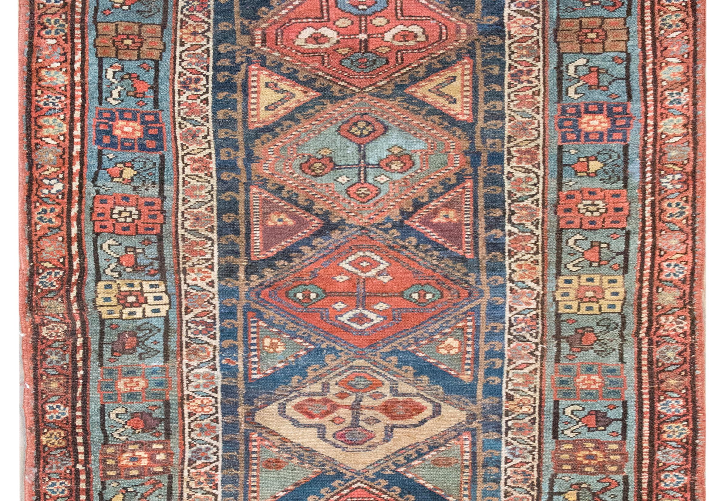 Questo straordinario tappeto persiano Azari dell'inizio del XX secolo è una testimonianza della ricca tradizione di tessitura dell'Azerbaigian. La serie di medaglioni di diamanti, ognuno dei quali è intricatamente ornato da motivi floreali