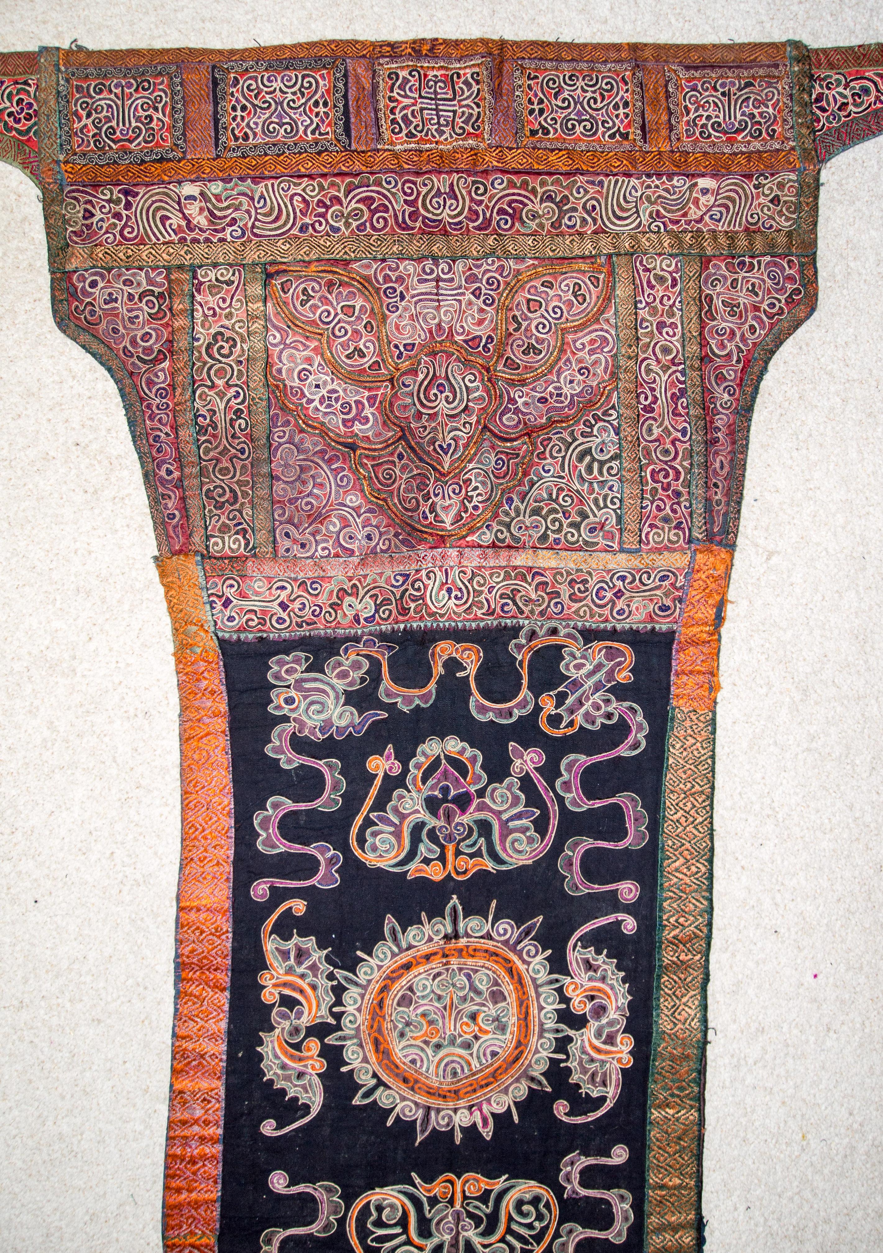 Early 20th century Baby Carrier, Shui Ethnic Minority. Guizhou, China. Incorporating horse hair embroidery.
This baby carrier comes from the Shui people of Sandu District in southern Guizhou. It exhibits a variety of embroidery and applique