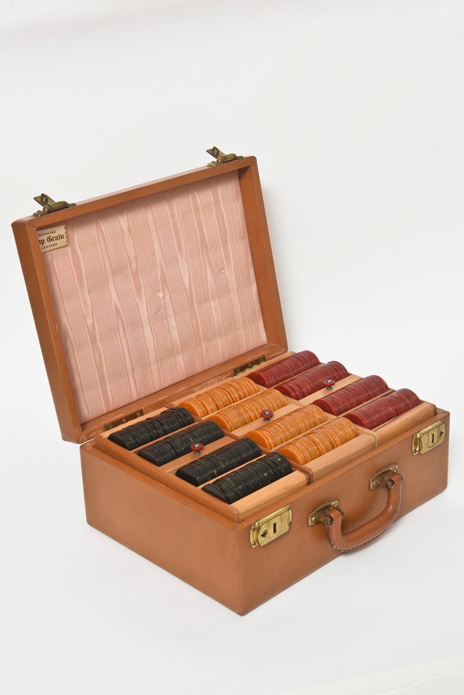 This is a magnificent 1930s two-tier travel poker set includes 6 removable wood chip rack holders that each have 4 sections. They lift out of the case with a bakelite knobs. The set has the original leather case with 2 hinged locks, the original key