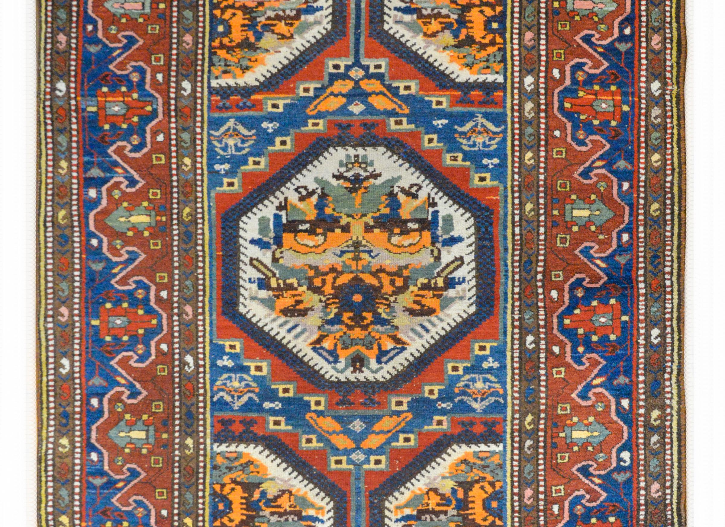 A wonderful early 20th century Persian Bakhtiari rug with an unusual floral partnered field woven in crimson, orange, indigo, sage green, and white wool, and surrounded by a beautiful border composed with a stylized floral and scrolling vine pattern.