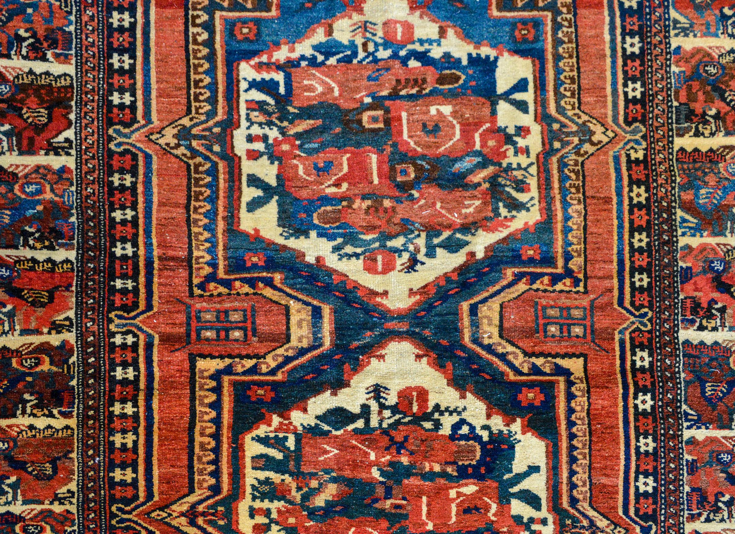 An outstanding early 20th century Persian Bakhtiari rug with two large central stylized floral medallions woven in crimson, blues, creams, and golds, and surrounded by a wonderfully woven border containing dozens of more stylized flowers.