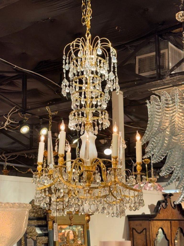 This early 20th Century Baltic chandelier features a stunning design with gilt brass, crystal and milk glass elements. With six lights, this chandelier exudes a sense of elegance and sophistication, making it a perfect addition to any interior
