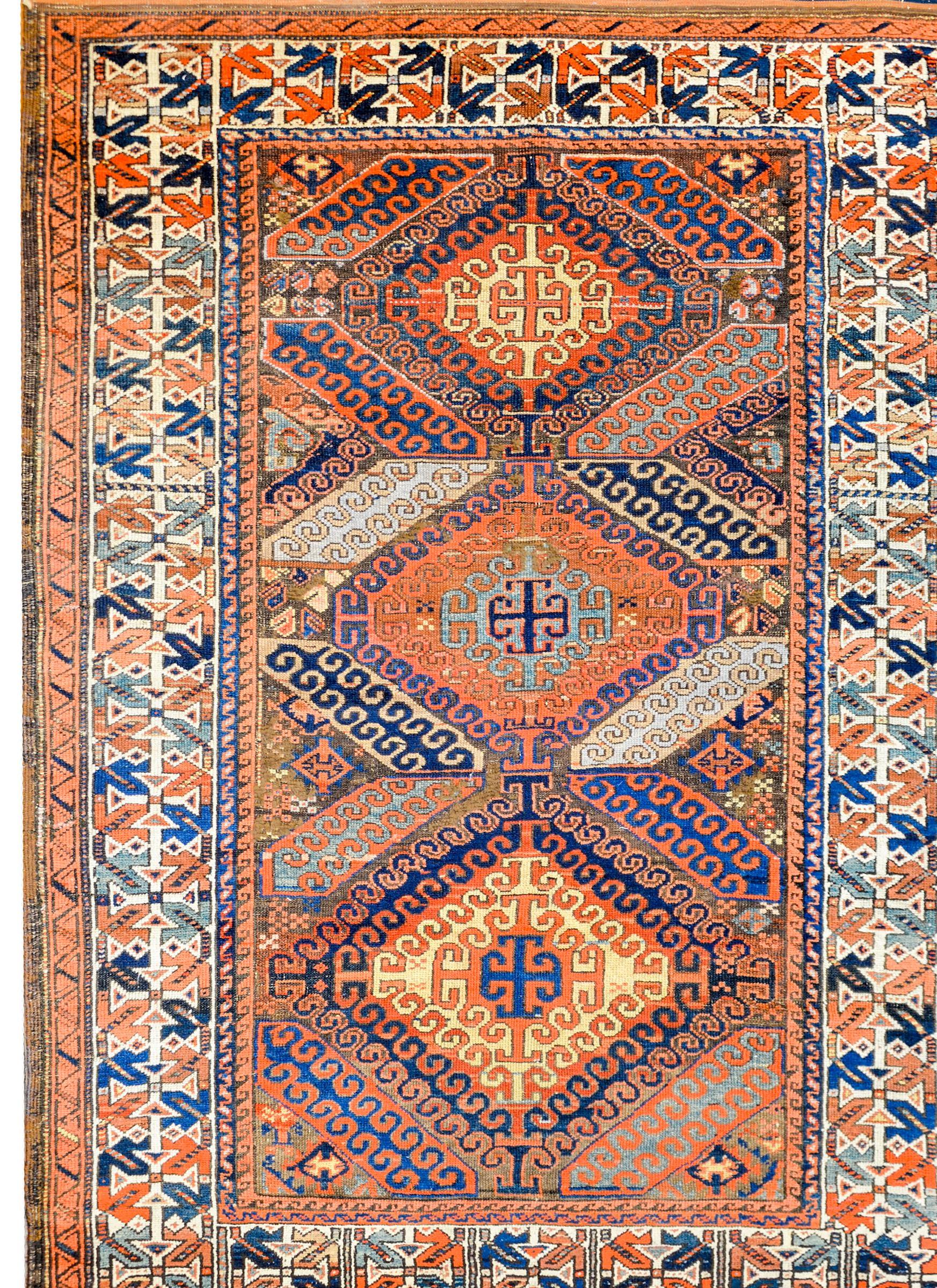 An early 20th century Persian Baluch rug with an incredible tribal pattern containing three large diamond medallions with scrolled stylized vines and woven in crimson, light and dark indigo, gold, and brown vegetable dyed wool. The border is
