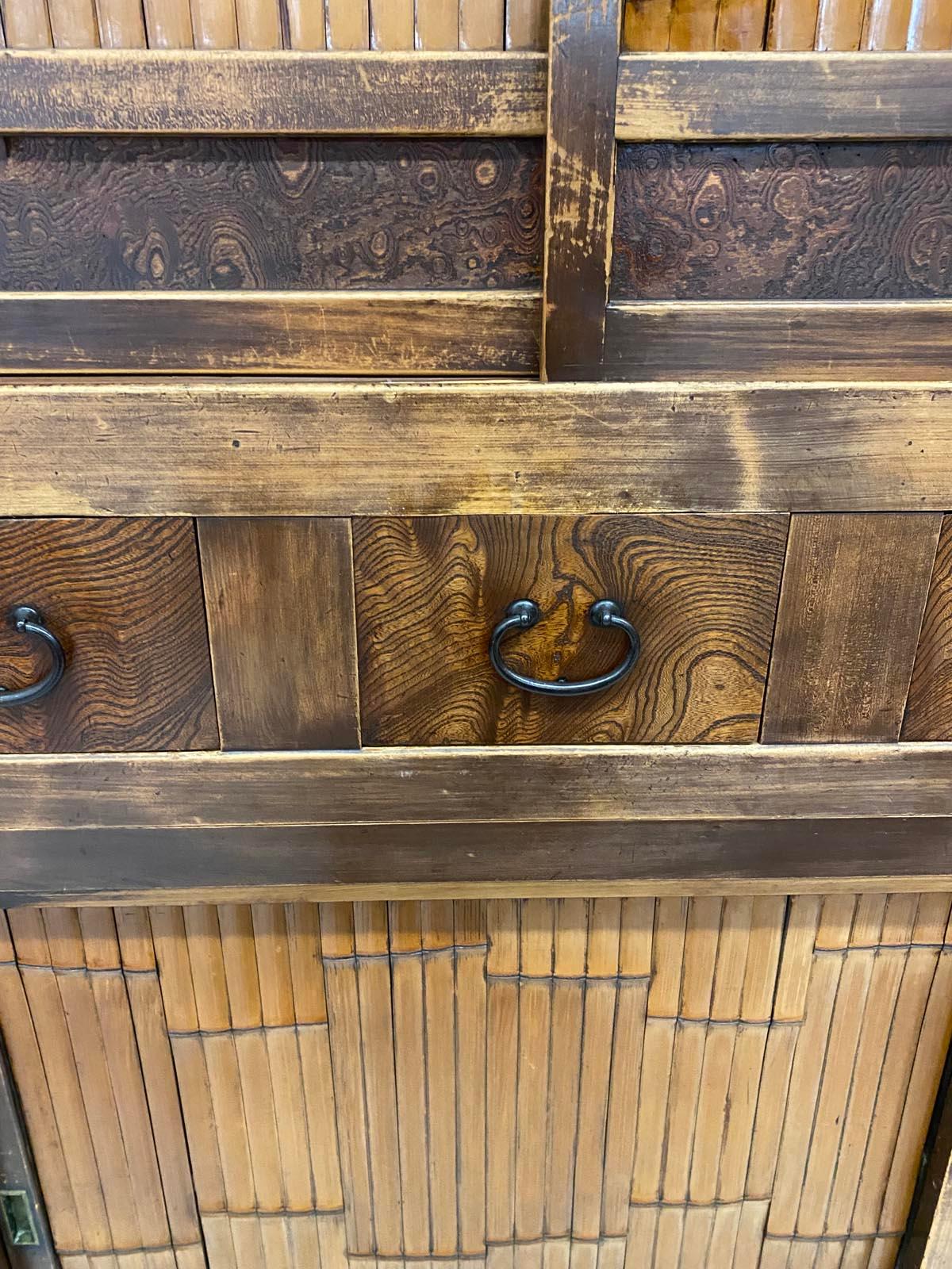 Early 20th c. bamboo and hinoki wood Japanese shop cabinet, two pieces. Sliding doors. All original including interior shelves.  The piece consists of variations of honey color brown using bamboo and burled wood as design accents on the two sliding
