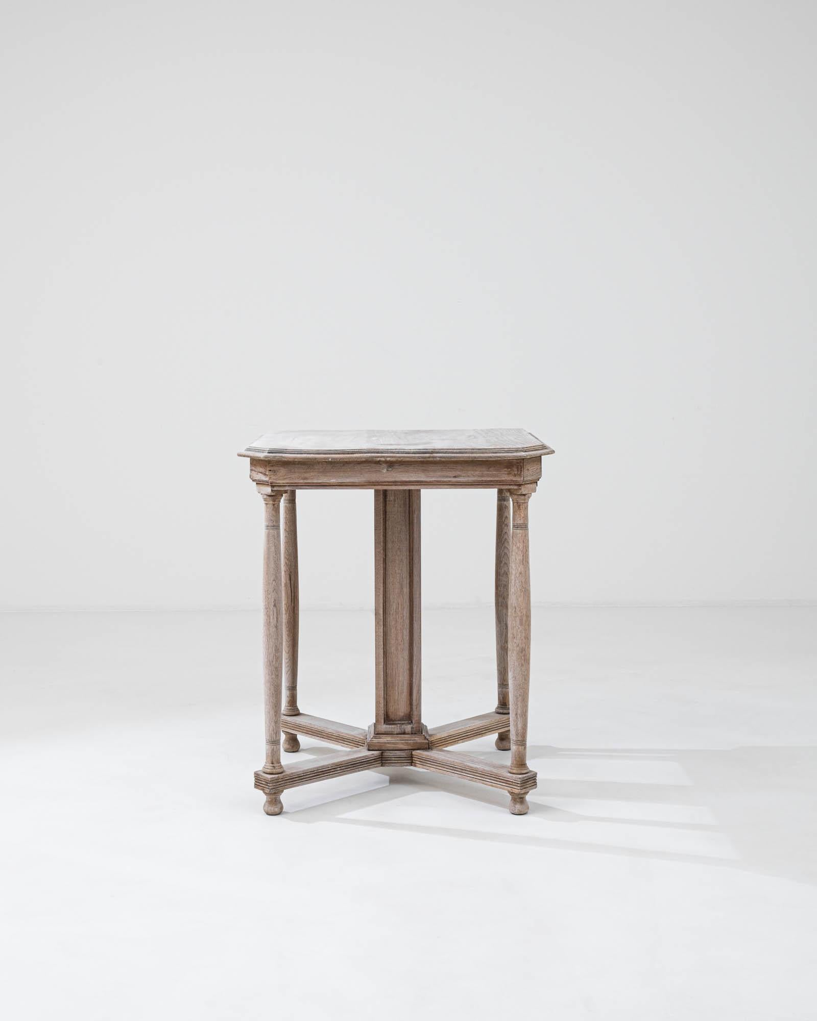 Step back in time with this exquisite early 20th-century Belgian side table, a testament to timeless craftsmanship. Constructed from robust bleached oak, its weathered texture and soft, whitewashed tone highlight the natural beauty and grain of the