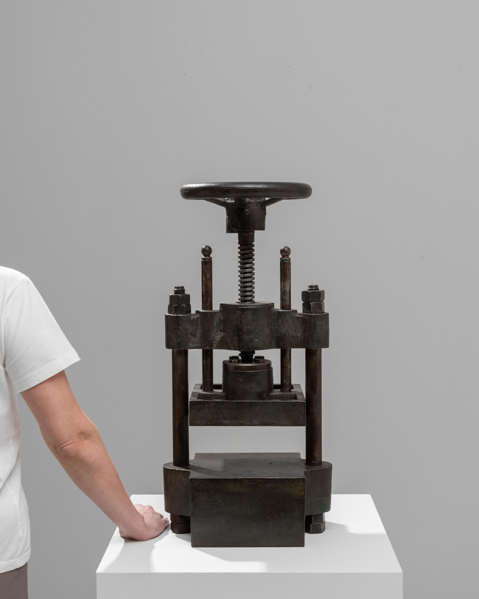 Discover the rugged charm of industrial design with this early 20th-century Belgian cast iron press. Designed to withstand the demands of heavy use, this piece is constructed from robust cast iron, featuring a sturdy frame and a bold, mechanical