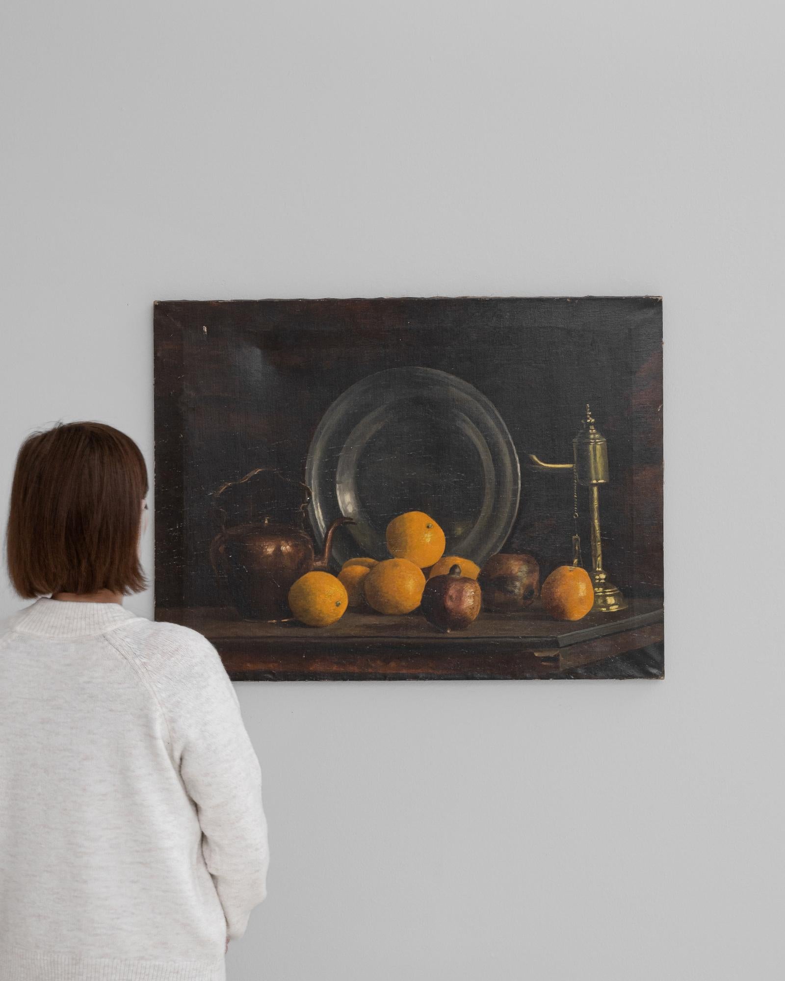 Dieses belgische Gemälde aus dem frühen 20. Jahrhundert ist ein klassisches Stillleben, das vom Können und der subtilen Brillanz seines Schöpfers zeugt. Vor einem dunklen, unauffälligen Hintergrund lässt die Komposition jedes Element mit einer